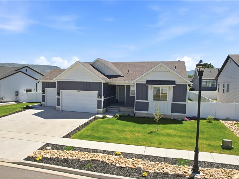 Welcome to Brookside in Heber City. Built in 2022 and set on a quiet cul-de-sac with mountain views, this nearly new 5-bedroom, 3-bath home offers 3,278 finished square feet, a 3-car garage, and the comfort of modern construction without the wait. The main level is bright and inviting with 9-foot ceilings, an open ranch-style layout, upgraded flooring, and a gas fireplace that anchors the living space. The kitchen is both beautiful and practical, featuring granite countertops, upgraded cabinetry, tile backsplash, cabinet lighting, a large island with extra storage, pantry, gas range, and reverse osmosis drinking water at the sink. The main-level primary suite offers a peaceful retreat with a spacious bedroom, walk-in closet, double vanity, soaking tub, separate shower, and upgraded bath finishes. An additional bedroom, a full bath, and laundry are also located on the main level. The finished lower level adds room to spread out with three additional bedrooms, a full bath, new carpet, wet bar, generous storage, and a living area prewired for surround sound. It is an ideal space for guests, movie nights, work, hobbies, or play. Thoughtful upgrades include approximately $153,000 in builder options, including the finished basement, 3-car garage, cold storage, upgraded cabinetry and countertops, gas fireplace, garage insulation, water softener, and reverse osmosis system. Outside, the fully landscaped yard is easy to enjoy with front and rear sprinklers, apple and peach trees, a porch, oversized patio, pergola, Stonehenge fencing, and wiring for lighting under the eaves. With nearby trail access, playground, and a convenient Heber Valley location, this Brookside home offers the space, comfort, and everyday livability buyers are looking for.