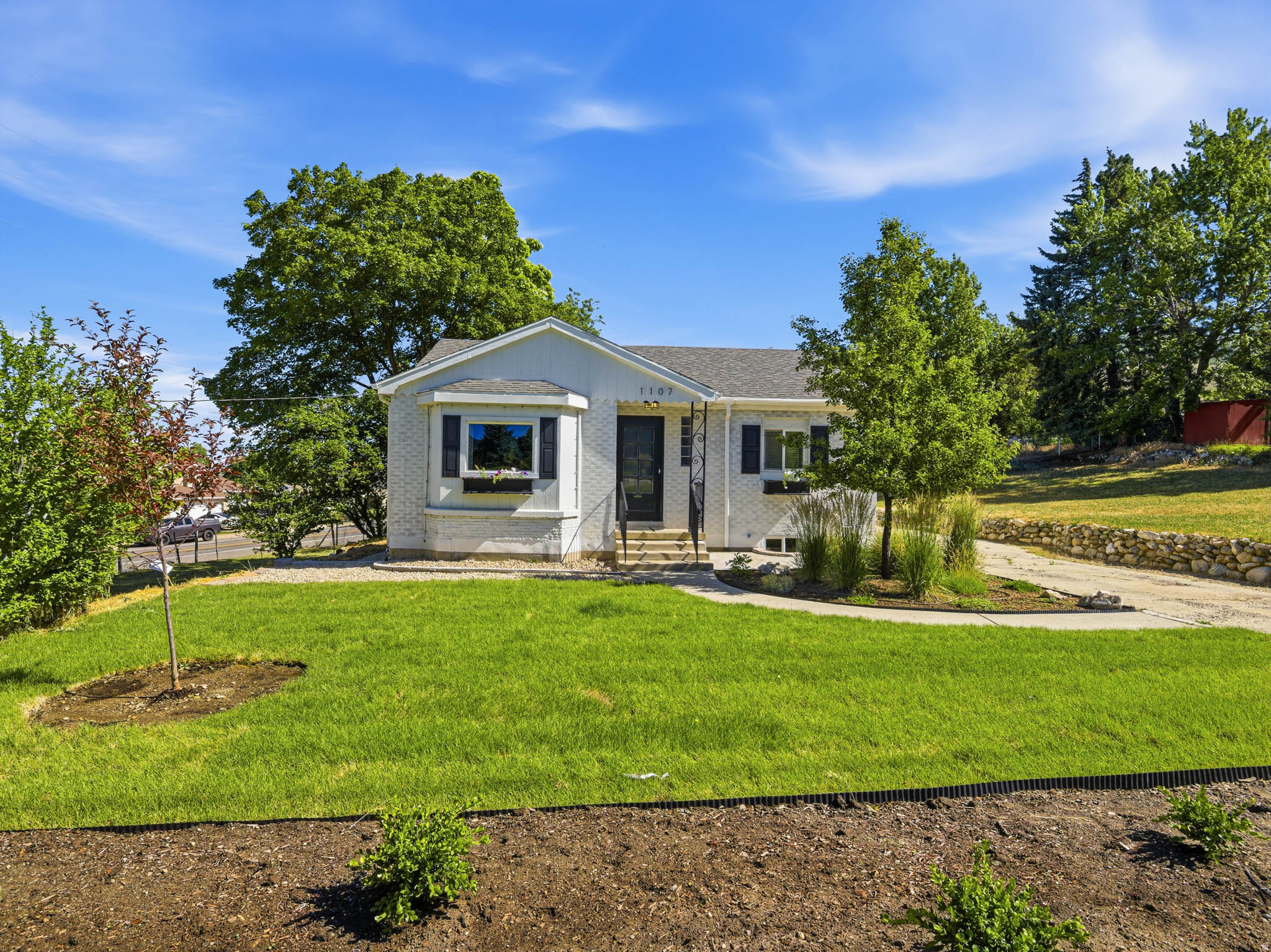 Set on an expansive and highly usable 0.40-acre lot in one of Bountiful's east bench neighborhoods, this property offers a rare combination of stunning views, timeless appeal, and future potential. Envision creating an incredible outdoor entertaining area, expanding garden space, adding a workshop, installing a pool, or simply enjoying the privacy and room to spread out. The generous lot size could also provide a future opportunity for an attached or detached accessory dwelling unit (ADU), offering valuable flexibility for multigenerational living or potential rental income. This elevated setting captures breathtaking sunsets, sweeping valley views, and sparkling city lights that create a spectacular backdrop day and night. Inside, the home has been thoughtfully updated throughout while preserving the distinctive details and inviting atmosphere that make it truly special. Refinished original hardwood floors add warmth and enduring appeal, while stylish designer touches bring a fresh, modern feel to the living spaces. Natural light fills the home, highlighting the seamless blend of classic craftsmanship and contemporary updates. Important improvements have already been completed, including an upgraded 100-amp electrical panel, as well as a newer furnace and water softener installed in 2024. The front yard has been beautifully refreshed with new landscaping and a new sprinkler system, enhancing both curb appeal and ease of maintenance. Conveniently located near schools, parks, shopping, dining, and freeway access, this property combines everyday convenience with the freedom and flexibility of one of the area's larger residential lots. Enjoy spectacular views, meaningful updates, investment potential, and a lifestyle that offers room to grow for years to come.