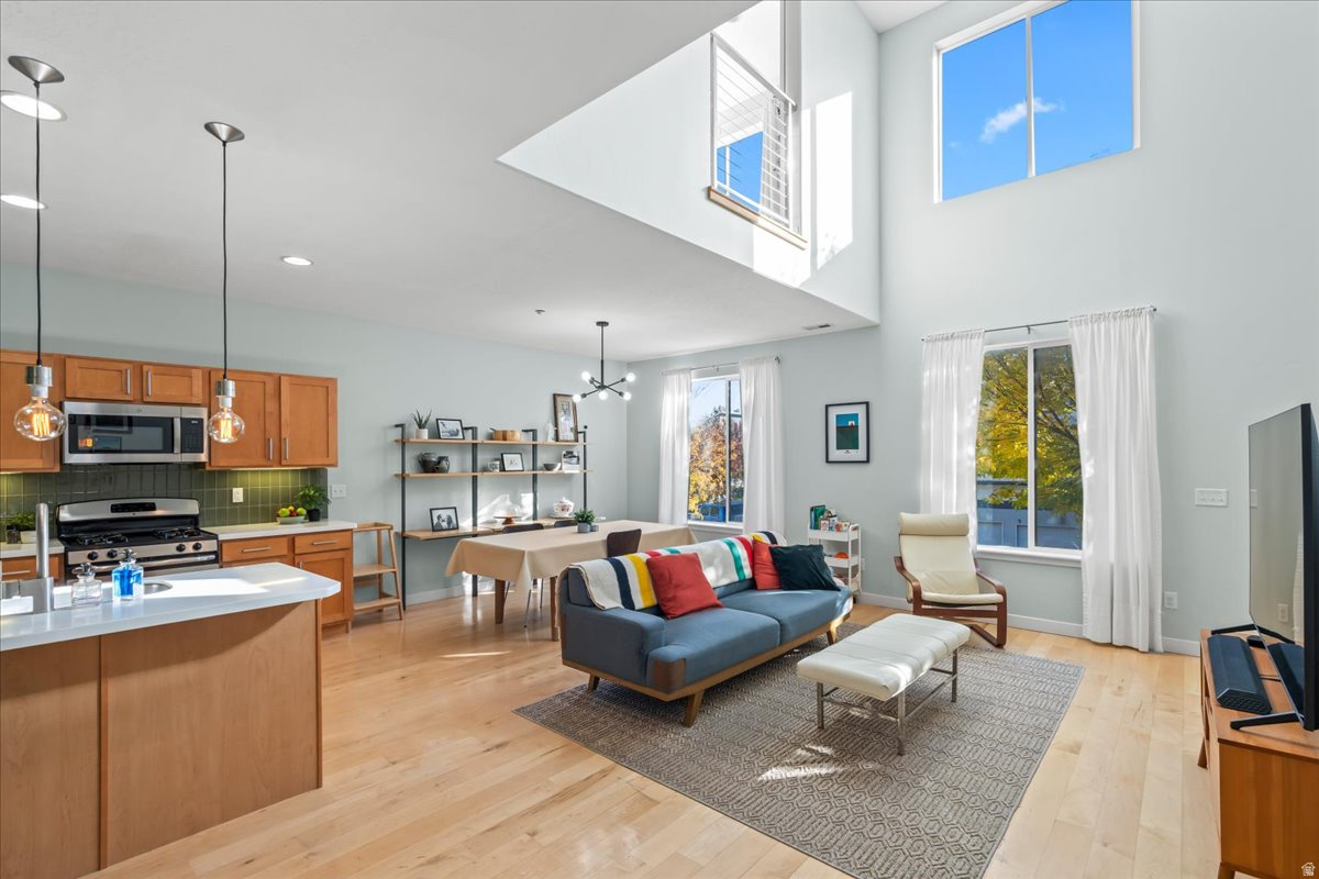 Don't miss this modern loft townhome featuring soaring vaulted ceilings and hardwood floors in a fabulous location. The open layout feels spacious yet connected, including an ensuite bedroom overlooking the living area below with elegant sliding panels for flexible privacy. The upstairs loft makes a bright and airy office or flex space. Nestled in a warm, welcoming neighborhood, yet you're 1-2 minutes from Target, Costco, and Walmart and abundant dining and shopping close by in The District. Relax and connect with neighbors in the community pool, hot tub and gym. Includes a 1-car garage, a designated parking spot, or nearby street parking. Built by Garbett as a certified Green Built home, it exceeds standard construction requirements for energy efficiency and sustainability. No rental cap, but initial lease must be for a term of at least 12 months. Square footage figures are provided as a courtesy estimate only; buyer is advised to obtain an independent measurement.