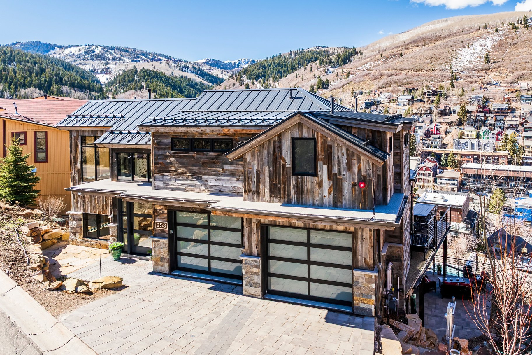 Perched at the end of a quiet cul-de-sac overlooking historic Old Town Park City, this exceptional luxury residence offers mountain modern living with breathtaking panoramic views and remarkable privacy. Built in 2022, the home features a stunning great room with soaring ceilings and expansive windows that frame sweeping ski area and mountain views while filling the home with natural light. The gourmet chef's kitchen is beautifully appointed with top-of-the-line professional appliances and wine fridge, clean modern lines, and high-end finishes, complemented by a spacious butler's pantry designed for effortless entertaining and everyday convenience. Thoughtfully designed and spanning approximately 5,054 square feet, the home offers five spacious bedrooms, each with beautifully appointed bathrooms and generous closets. The spectacular primary suite occupies its own private level and features dual walk-in closets, double vanities, a luxurious bath and shower, a loft office, separate laundry, and a private deck with stunning views. Outdoor living is a highlight, with four decks and a patio offering generous space for dining, entertaining, and relaxing while taking in unobstructed mountain and ski area views. Additional features include a secondary Family Room with full wet bar, refrigerator and dishwasher, radiant in-floor heating, central air conditioning, three fireplaces, Media Room, private hot tub, and a rare two-car garage with a heated driveway. Ideally located just minutes from world-class skiing, hiking and biking trails, renowned dining, and Historic Main Street, this rare opportunity captures the very best of Park City luxury and lifestyle in one of Old Town's most sought-after settings.