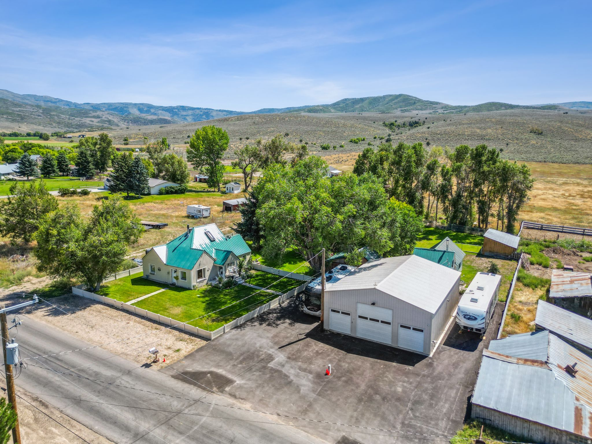 Super charming cottage home, located in one of the most serene areas in the Heber Valley. The main home offers 3 bedrooms, 2 baths, and the detached mother-in-law apartment offers an additional bedroom, vaulted living room, full kitchen and bathroom. The supersized garage shop is insulated, temp controlled and has plenty of space for parking and storage. The main home is on 1 acre, and is being sold with the additional 8.3 acre parcel directly behind it for a total of 9.3 acres. The properties include 4.5 water shares. The main lot is simply beautiful with its manicured lawn, mature trees, stream flowing seasonally, and additional out buildings. Easy access right from the driveway to many recreational areas and activities. Enjoy country living while still having all of Heber's conveniences just minutes away. The main home is currently rented for $1,800 per month and the mother in law apartment is rented for $1,500 per month. Tenants can stay or vacate with 30 days notice. Additional land parcel ID No. 00-0009-4487.  Buyer to verify. Information provided as a courtesy.