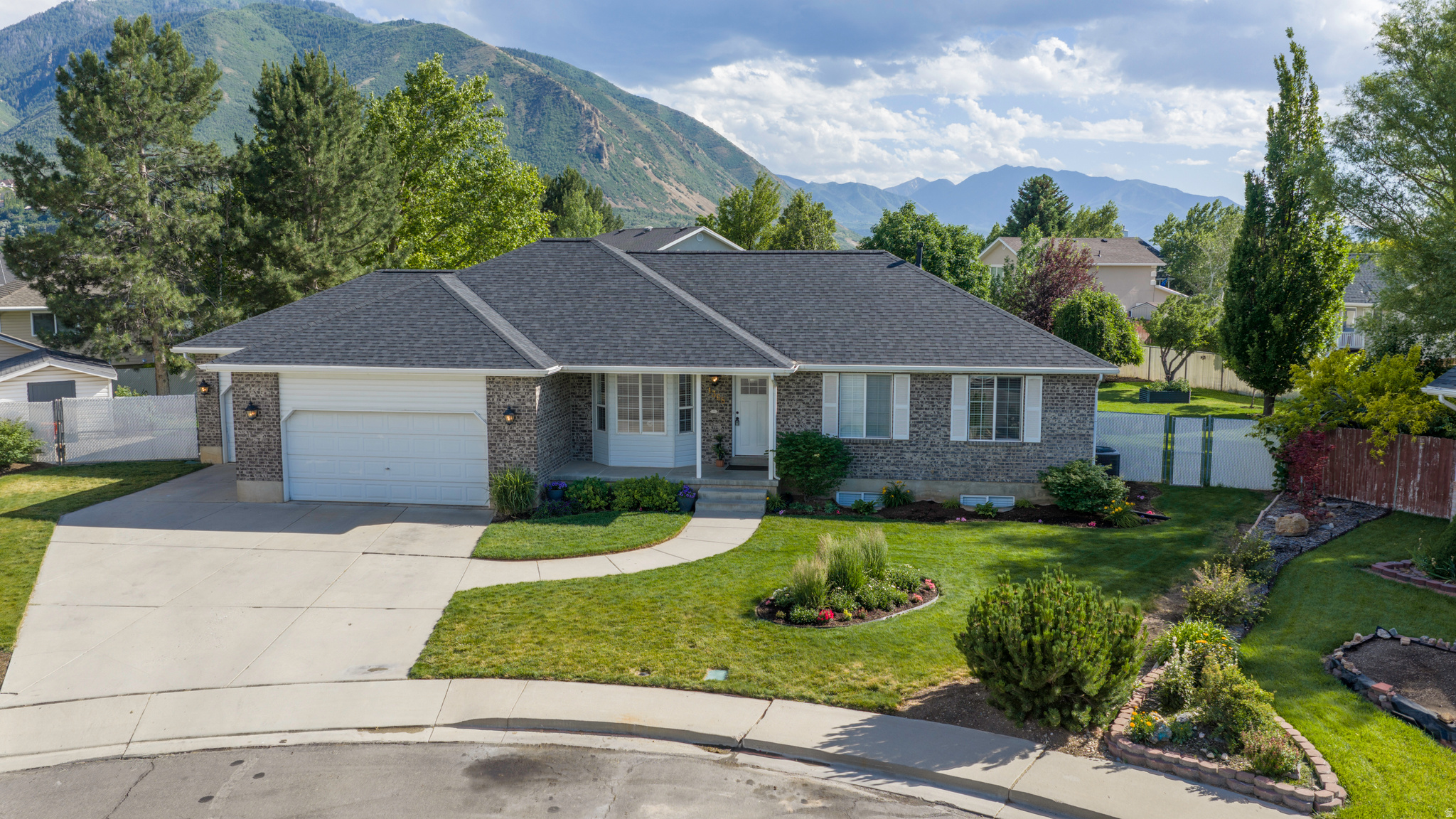 All-brick rambler on a 0.37-acre lot offering 5 bedrooms, 3 full bathrooms, 1,657 square feet on the main level, and a 1,741-square-foot finished basement. Vaulted ceilings span the main floor. The main kitchen features granite countertops, 20-inch tile flooring, an island, bar seating, and a butler's pantry with an adjacent laundry room. The finished basement includes a second kitchen with quality cabinetry, quartz countertops, range, microwave, refrigerator, gas fireplace, cold storage, storage room, built-in ceiling-mounted projector screen, and included Epson projector. Bathrooms throughout the home have been remodeled with quartz countertops, updated tile surrounds, and a euro-glass shower and large soaker tub in the primary suite. New carpet has been installed on both levels. Additional features include a water softener, finished 3-car garage, garage subpanel, and 220 power for welding or EV charging. The fully fenced and fully sprinklered yard features mature landscaping, a large concrete patio, garden areas with drip irrigation, blackberries, an in-ground trampoline, and a large storage shed. Downstairs bedrooms are oversized, and the basement layout offers ADU potential with minimal modifications and the addition of exterior access. Roof replaced in late 2024. Located approximately 2 minutes from Canyon View Park, The Oaks Golf Course, and the Spanish Fork River Trail, 5 minutes from Adventure Heights All-Abilities Park and Spanish Fork Canyon recreation, 57 minutes from shopping, dining, and the Spanish Fork retail corridor, and approximately 4 minutes from I-15 access.
