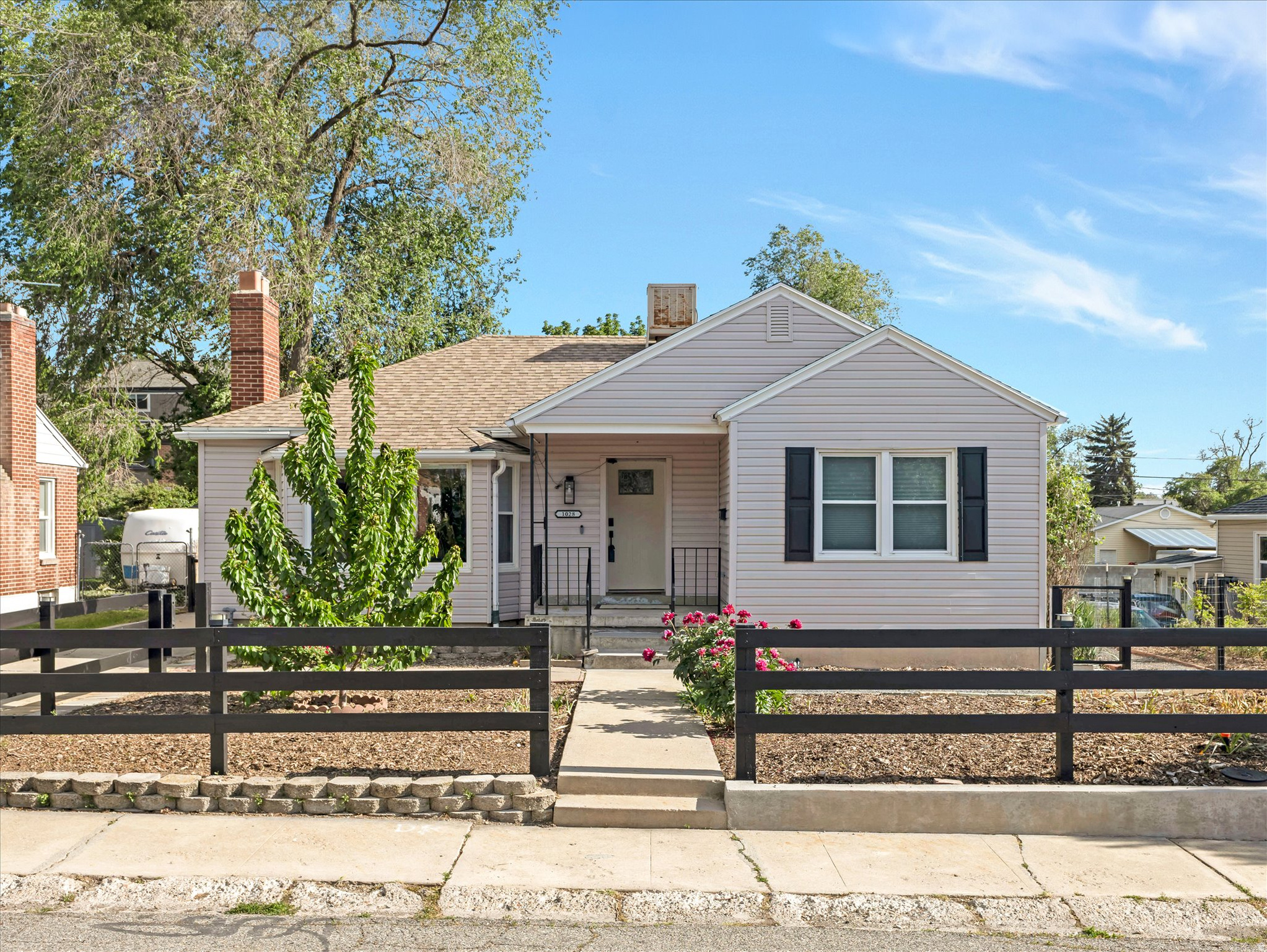 Don't miss this stunning, fully updated home in the heart of highly sought after Millcreek. Ideally located within walking distance of Millcreek Commons, where you can enjoy year round community events including skating, concerts, farmers markets, shopping, dining, and more. Centrally located near schools, parks, and shopping, with quick access to I-215 for an easy commute anywhere in the valley or fast access to world class skiing, hiking, biking, climbing, and outdoor recreation in the nearby canyons. From the moment you arrive, you'll appreciate the exceptional curb appeal with clean modern siding, striking black trim, and thoughtfully designed water wise landscaping that helps conserve resources while reducing utility costs. Fully paid off solar panels provide additional energy savings and environmentally conscious living. Step inside to an inviting open concept main living area featuring beautiful flooring, abundant natural light, and a beautiful cozy fireplace. The updated kitchen showcases stylish gray cabinetry, crisp white granite countertops, recessed lighting, a large single-basin sink, and sleek black appliances, including a premium gas range with upgraded ventilation system. The spacious breakfast bar and separate dining area with designer chandelier create the perfect setup for both everyday living and entertaining. The main level also offers two spacious bedrooms with upgraded split blackout blinds and a beautifully updated full bathroom with modern finishes. Downstairs, you'll find a comfortable family room perfect for movie nights, games, or relaxing, along with three additional spacious bedrooms, another stylishly updated full bathroom, a large laundry area, and ample storage space. The backyard has been thoughtfully designed to balance comfort, functionality, and sustainability. Enjoy relaxing or entertaining on the fully covered patio while taking advantage of five young fruit trees that are already bearing fruit; including Bing cherry, Asian pear, yellow peach, pluot, and Rainier cherry and a newly installed sprinkler system for easy maintenance. The extra long driveway can fit three cars and the detached two car garage provides plenty of parking and additional storage space. This home is truly move in ready with extensive upgrades already completed, including newer furnace, A/C, water heater, roof, windows, and appliances. Additional health and safety improvements include a whole house humidifier system, radon mitigation system, and full asbestos mitigation. Combined with the water wise landscaping and fully paid off solar panels, this home offers comfort, efficiency, peace of mind, and long term savings all in one exceptional package.