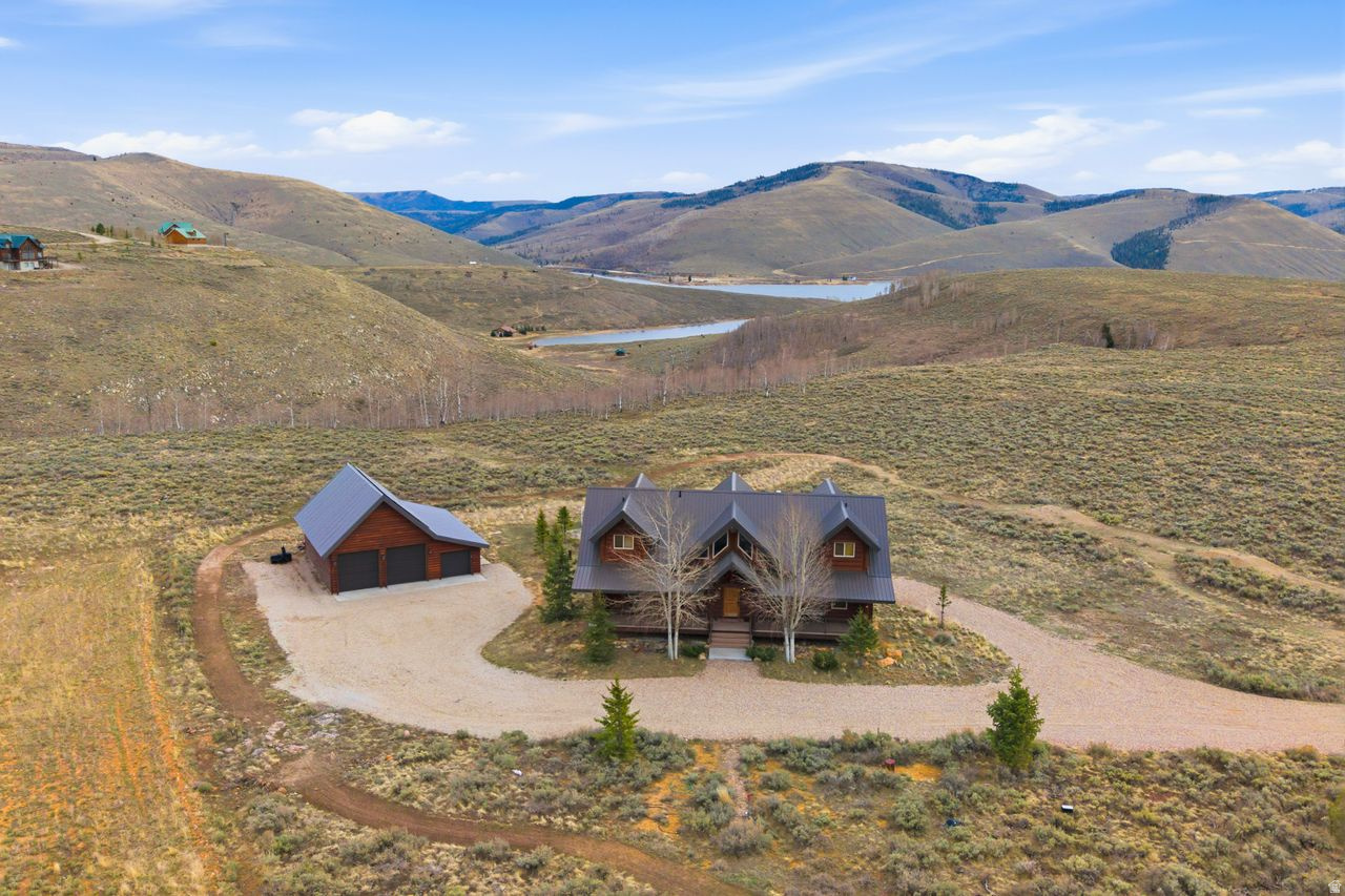Escape to Your Private Year Round Alpine Oasis-Aspen Cove at Scofield Reservoir!  Discover unparalleled mountain living in this magnificent 5-bedroom, 5-bathroom custom log cabin, nestled within the exclusive, gated Aspen Cove community.  This retreat is designed for unforgettable family memories, four-season adventure, and unparalleled peace.  A stunning, custom-built log cabin featuring vaulted ceilings, exposed timber, and expansive panoramic windows that seamlessly bring the serene beauty of the mountain and lake views indoors.  Meticulously designed across three levels,  your new escape provides ample room for multi-generational gatherings or corporate retreats.  The gourmet kitchen is chef's delight, high-end appliances, custom cabinetry, and premium stone countertops are perfect for large family dinners or entertaining.  The floor-to-ceiling stone fireplace is the heart of the great room, while a dedicated game room or theater area awaits on the lower level along with an upper level loft.  The bedrooms include or are paired with their own bathrooms, offering luxury and privacy.  Step out onto an expansive wrap-around deck to enjoy crisp mountain air, stunning lake views, and evening stargazing.  Located on a 4.83 acres with an extra large garage to store vehicles and toys for easy access to boating, fishing, hunting, snowmobiling or exploring the mountains on your UTV.  Circling the property is a custom built mountain bike/bmx trail.    Aspen Cove Perks: A quiet, secure gated community with a common pavilion for community gatherings, pickleball, tennis, basketball and frisbee golf. With a Utah State Parks pass included in ownership, you are only minutes from the boat launch on the 2,800-acre Scofield Reservoir, famous for Blue Ribbon fishing (Trout) and water sports.  Whether you are seeking a premier investment property, a vacation getaway, or a permanent mountain lifestyle, this Aspen Cove cabin is the ultimate mountain destination.