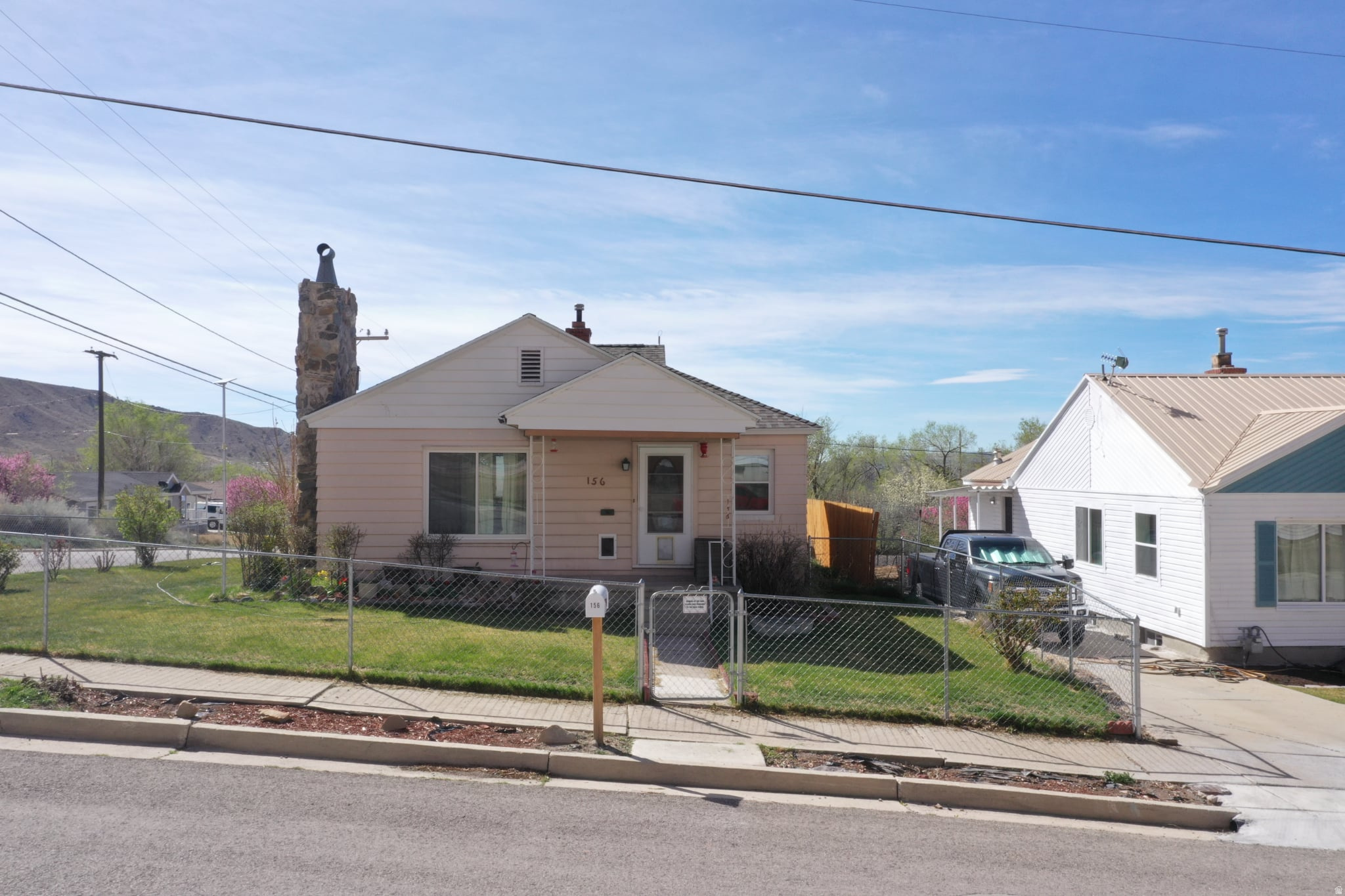 This charming 1940-built bungalow in Helper offers a spacious floor plan and absolutely exquisite views of the surrounding mountains. With a total of 2,065 square feet, the home features three bedrooms, two bathrooms, and a basement that is 80% finished, providing ample space for a new buyer, investor, or someone ready to retire. The interior includes a mix of hardwood, carpet, and laminate flooring, along with a formal living room, a family room, and a cozy wood stove. Practical amenities such as a water softener, central forced air heating, and an evaporative window cooler ensure year-round comfort. Situated on a 0.15-acre flat lot, the exterior boasts aluminum siding, mature trees, and both covered and open patio spaces for enjoying the outdoors. Parking is a breeze with a circular driveway, RV parking, and a detached garage that offers additional storage. Located within the Carbon School District and close to Sally Mauro Elementary, this home is easy to show and full of potential for its next owner.with $5,000 Consessions