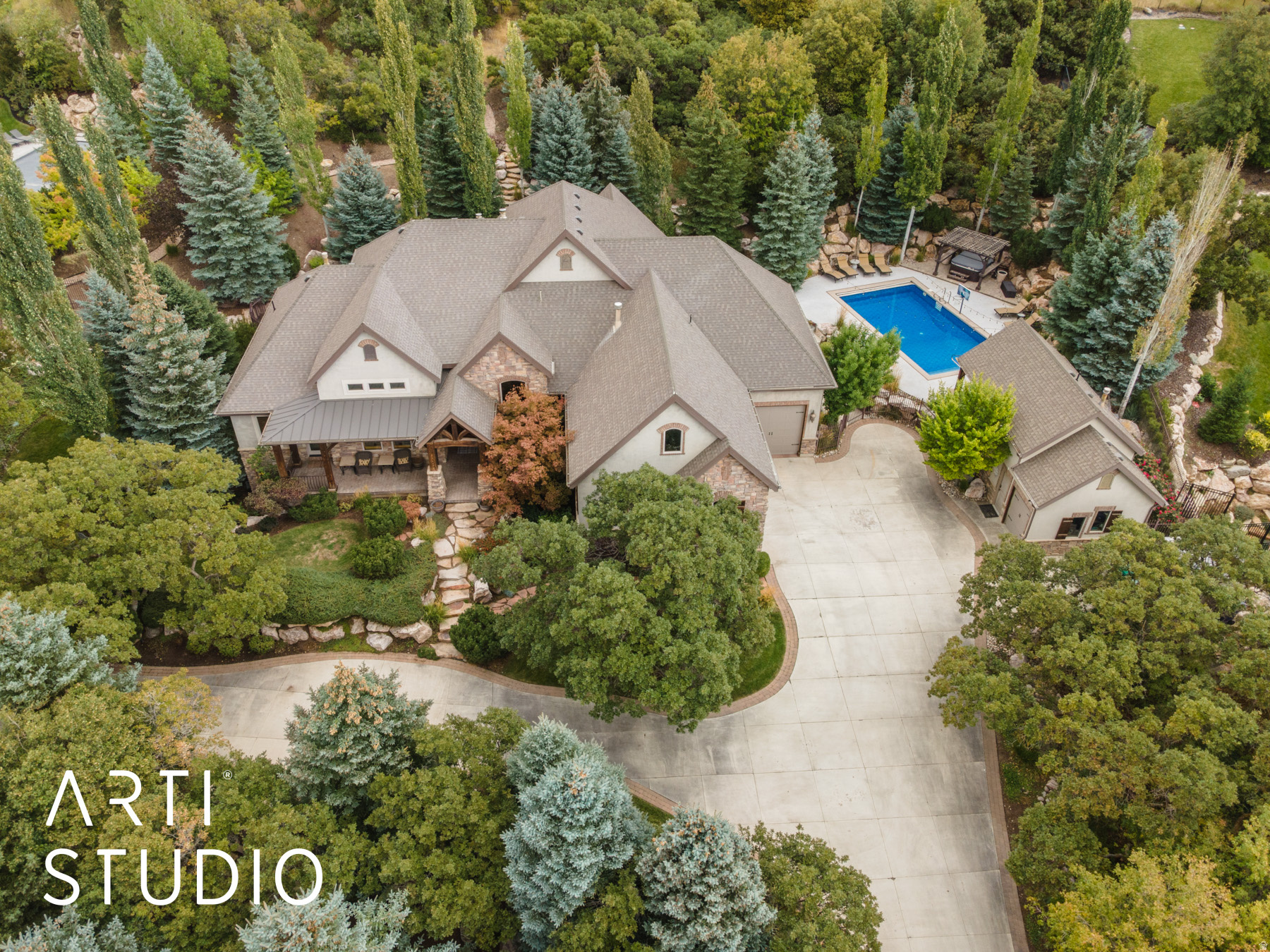 Here's your chance to own your own private mountain resort! Perched gracefully on 3.67 private acres along Layton's coveted East Bench, this extraordinary Estate offers a rare blend of refined craftsmanship, natural beauty, and resort-inspired living. Framed by sweeping, unobstructed vistas of the Wasatch Mountains, valley below, and shimmering Great Salt Lake, the setting is nothing short of breathtaking. A winding circular drive, bordered by curated stonework and artful landscaping, sets a grand tone upon arrival. The residence itself is a masterclass in design, where timeless materials and impeccable attention to detail converge. Inside, a dramatic foyer welcomes you with rich hardwood flooring, new carpet throughout, soaring ceilings with natural beams, and a striking floor-to-ceiling stone fireplace-creating an atmosphere both warm and sophisticated. The home's expansive layout is designed for both elegant entertaining and everyday comfort. A vaulted great room captures natural light through oversized picture windows, seamlessly connecting indoor living with the surrounding landscape. Multiple fireplaces throughout the home add depth and ambiance, while custom millwork, solid alder doors, and refined finishes underscore the home's elevated character. At the heart of the home, the gourmet kitchen is thoughtfully appointed for culinary excellence, featuring premium appliances, double ovens, a warming drawer, and an oversized granite island ideal for gathering. A butler's pantry with additional cooling drawers enhances both functionality and style, while a nearby wet bar-complete with beverage fridge and custom cabinetry-creates the perfect setting for hosting. The primary suite is a serene retreat, offering a private sanctuary with its own fireplace, spa-inspired bath with heated floors, soaking tub, dual vanities, and a spacious walk-in closet. Direct access to an outdoor hot tub invites relaxation beneath the stars. Additional spaces include a beautifully appointed home office with private entrance, formal and informal dining areas, and a thoughtfully designed mudroom and laundry area. The lower level continues the home's entertaining focus with a large gathering space, fireplace, game area, and a full bar with wine cellar -perfect for hosting on any scale. Outdoors, the estate transforms into a private resort. A heated in-ground pool with automatic cover anchors the backyard, complemented by a pool house featuring a kitchenette and changing facilities. Expansive covered patios, fire features, and multiple seating areas provide year-round enjoyment in a setting designed for both relaxation and celebration. Car enthusiasts and hobbyists will appreciate the oversized 3-car garage with additional toy storage, while modern conveniences such as a whole-home generator, tankless water heating, and advanced air systems ensure comfort and efficiency. Bordering protected land, this property offers exceptional privacy while still being moments from city amenities! You are only 20 minutes from a world renowned ski resort, and 25 minutes to Pineview reservoir. Want more, there are hiking and biking trails just a few hundred yards from your driveway, -This estate creates a lifestyle that is as tranquil yet convenient.