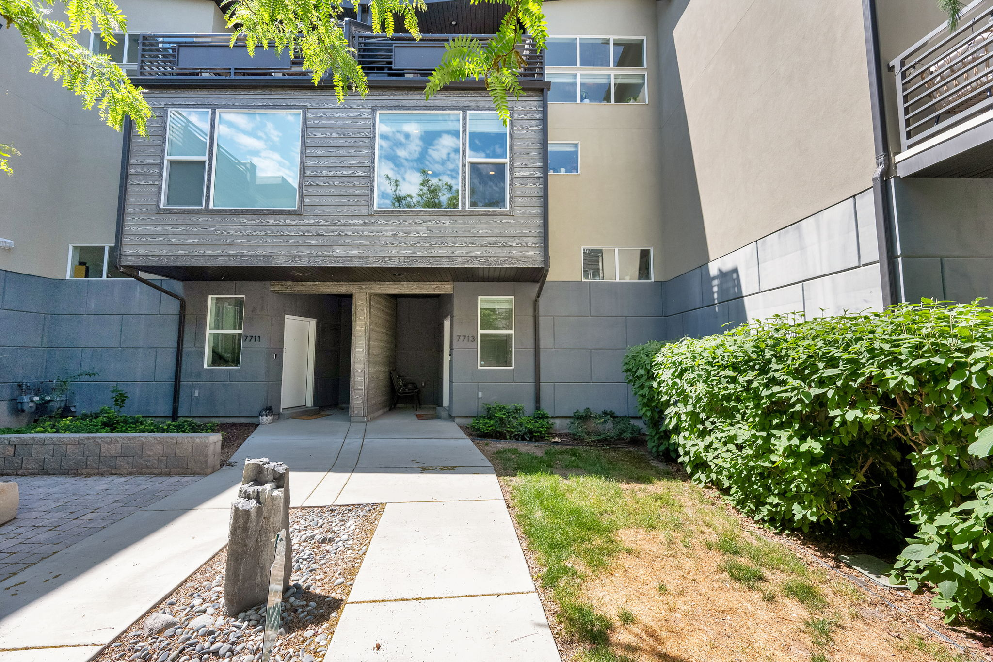Gorgeous bright newer contemporary townhome located in the desirable and convenient Rooftop at 78 Community of Midvale. Open and spacious floorplan with vaulted ceilings and huge picture windows bringing in lots of natural light.Main floor entry leads you upstairs to an open living space featuring beautiful faux wood floors, high ceilings and recessed lighting. Nicely appointed modern kitchen with polished quartz counter tops, custom glass backsplash, white laminate cabinets, stainless steel appliances, gas range, ample storage and counter space and an island with breakfast bar seating as well as a kitchen dining area. Spacious main floor laundry and bedroom that is currently being used as an office/guest room. Full tiled European bathroom and a walk in closet connecting the bathroom to the bedroom.UPSTAIRS: Primary Bedroom with high ceilings, big picture windows, recessed lighting, walk in closet with built ins that connects to an en-suite Primary Bath with double vanities, tiled tub and shower and tiled floors. Additional second bedroom with full tiled bath and floors.Walk out to a fabulous deck with views.HOA: Transfer Fee $350, Monthly HOA fee is $233.76 with an additional cost of $47 per month to use the pool and spa next door at the Lofts Apts totaling $280.76 but is optional. HOA covers fire pit, playground, sewer paid, trash paid, biking trails, Pet Rules (up to 3 pets) exterior insurance on building, Fiber Internet, pool, snow removal, water paid, maintenance paid, Club House, Gym Room, and Picnic Area. There is a current assessment in place but seller will pay off at closing. There is also a 5% yearly HOA increase each year.Conveniently located near I-15, all shopping, Jordan River, Multiple Parks, Restaurants, Top Golf, Gardner Village, and much more.Other special features include new water heater March 2026, 1 year old washer, replaced furnace coil 2021, 2 car garage with storage and automatic garage door opener, central air conditioner, gas forced air furnace, electric dryer hookups, stucco and clapboard exterior, double pane windows, outdoor lighting, washer and dryer included in sale, gas range, refrigerator, dishwasher, disposal, microwave....all included and window coverings to stay. Landscaping includes mature trees and pines and sidewalks. This home showcases Pride of Ownership and is a pleasure to show. Truly a home in excellent condition and shows like a model home.