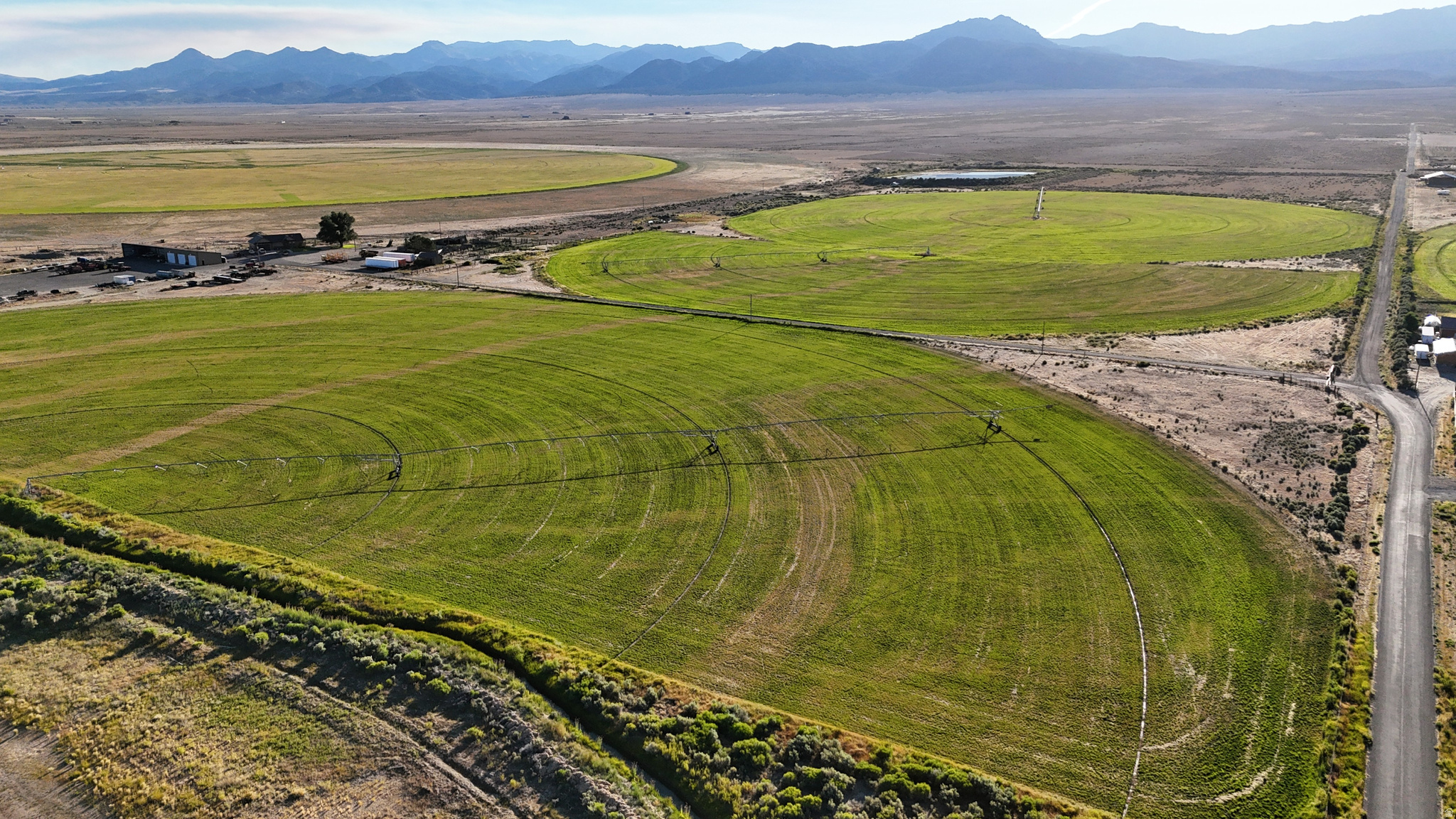 Located in Garfield County, Utah, this 467-acre high-elevation agricultural property offers a combination of irrigated production ground, infrastructure, water resources, and residential improvements. The property includes 205 acres of irrigated hay ground under modern pivot systems, room to expand to over 300 acres of production, with the remaining acreage consisting of additional agricultural land, infrastructure sites, and support ground. The irrigated acres are managed on a three-way crop rotation consisting of alfalfa hay, triticale, and timothy. These crops are produced at elevation and supported by an updated water delivery system that includes holding ponds and a custom pivot equipped with a variable frequency drive. The property is conveyed with sufficient water shares to support three cuttings in an average production year. Average yields have historically exceeded six tons per acre, based on operator records.  Forage output has been routinely tested through Dairy One Forage Testing, with results placing production in the high-quality category: Dry Matter, Crude Protein, ADF, NDF, TDN, and feed value. Management practices have focused on soil health and microbiology, with reduced fertilizer inputs and no routine use of pest control products. Hay handling infrastructure includes Staheli West steamers, covered storage, and dedicated hay barns designed to preserve forage quality during storage and transport.  Improvements include a 3,400-square-foot custom home constructed in 2018. The residence features five bedrooms and three and one-half bathrooms, with a functional layout suitable for full-time living or extended stays. The home has been maintained and updated since its construction in 2018. Additional improvements include corrals for livestock, a three-sided hay barn totaling approximately 10,000 square feet, a 2,700-square-foot heated shop, and approximately 3,600 square feet of covered parking. These structures support equipment storage, hay handling, and general agricultural operations.  The property is fully fenced and accessed by a paved county road. Utilities are in place to support both residential and agricultural use. The layout and infrastructure allow for continued hay production, livestock support, or diversified agricultural use. The acreage and improvements may also support agritourism or farm-based hospitality uses where permitted by county zoning and applicable regulations. Buyers are advised to verify allowable uses with Garfield County.  The farm is located north of Panguitch, Utah, in a rural agricultural setting with convenient access to regional services. Panguitch is approximately 9 miles south of the property. Bryce Canyon City is approximately 29 miles southeast, Beaver is 45 miles northwest, and Cedar City is approximately 67 miles southwest. The area is known for its agricultural heritage, open space, and proximity to public lands and outdoor recreation, including Bryce Canyon Country.  This offering presents a combination of scale, water, improvements, and access in a central Utah agricultural setting, suitable for continued production or diversified rural use without reliance on speculative assumptions.