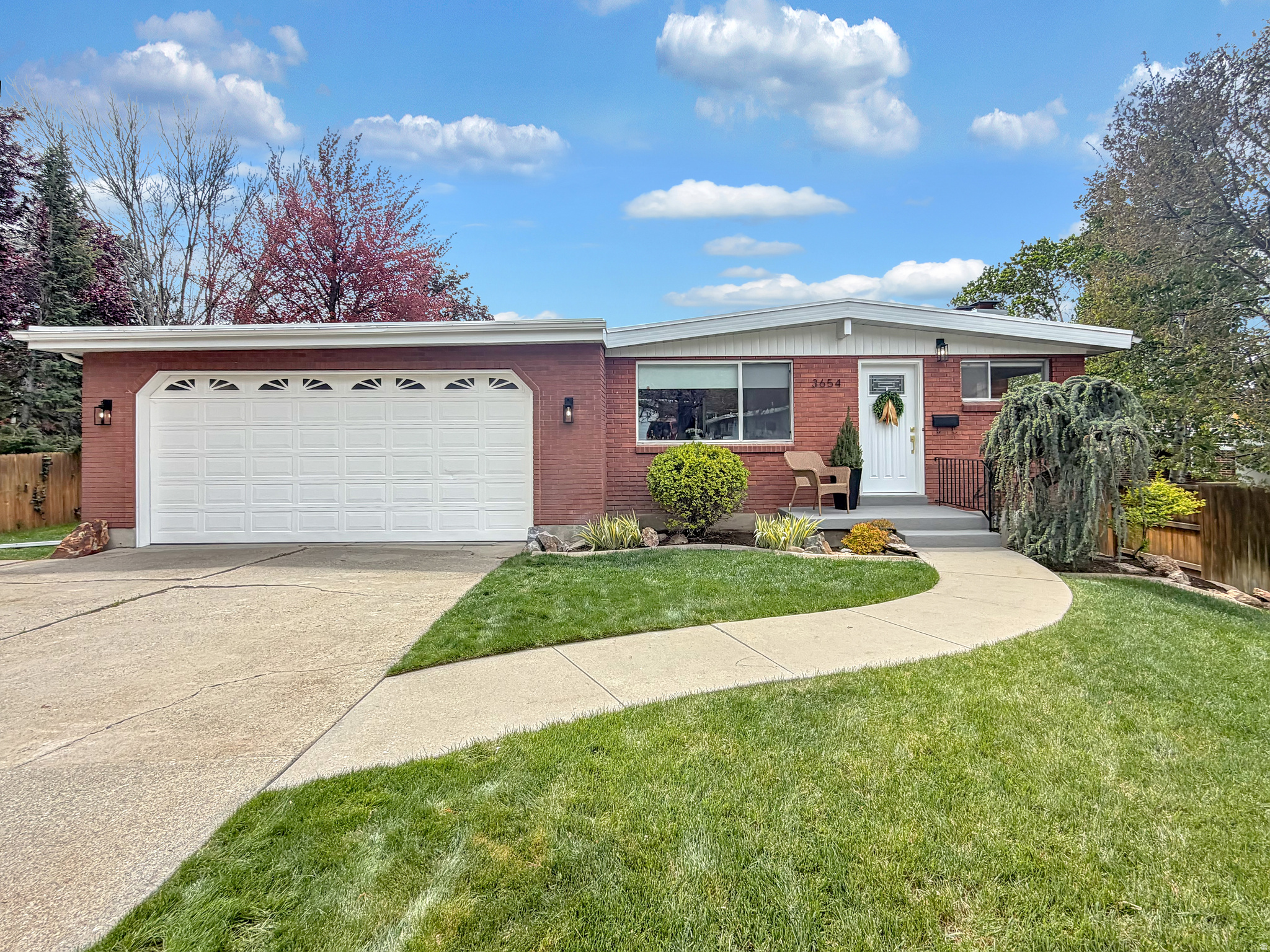 HUGE PRICE REDUCTION! This price in this neighborhood is rare. OPEN HOUSE this Saturday 6/6, 2-4 pm. Located in the highly sought-after Olympus Cove neighborhood, this beautifully updated brick rambler blends timeless mid century modern charm with thoughtful, modern upgrades. Clean lines, expansive windows, and an open, airy feel create a light filled living experience throughout, enhanced by large picture windows and daylight basement windows that bring in an abundance of natural light on both levels. Real hardwood floors, original cabinetry and woodwork, and striking redwood accent walls on the exterior add warmth, character, and authentic mid century appeal.  The main living space features a cozy gas fireplace and flows seamlessly into an updated kitchen with sleek quartz countertops, offering both style and functionality. Downstairs, a massive family room provides the perfect gathering space, with walk out basement access, ideal for entertaining or relaxing. Outside, tucked in the foothills of Mt. Olympus, this home truly shines with a beautifully landscaped yard filled with mature trees that provide shade and privacy. An expansive terraced deck with a pergola creates the ultimate outdoor retreat, perfect for summer evenings, entertaining guests, or simply enjoying the serene surroundings. The perfect blend of nature, comfort, and charm in this inviting, mid century modern gem.