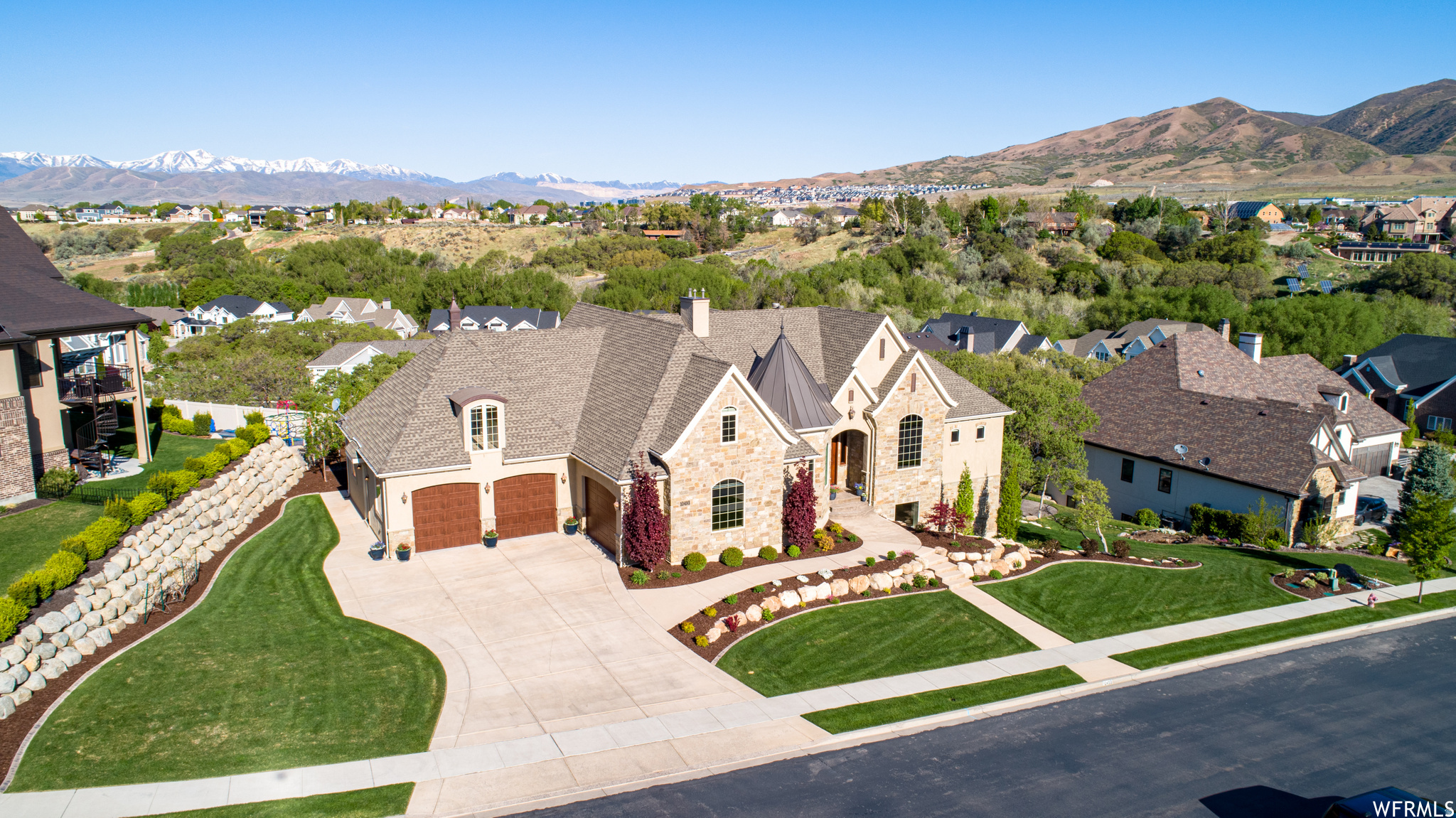 This Stunning Executive Estate (See the Attached Tour Video - Click to See Video), perfectly perched atop the prestigious Highland Hollow, captures breathtaking panoramic views and showcases exceptional craftsmanship throughout its 7,287 sq ft of refined living space. The Main floor welcomes you with a Grand Foyer Entrance, Soaring 1014 ft ceilings, and Large View-Filled Windows that flood the home with natural light, Custom Fireplace with Bookshelves, a Large Open Family, a Gourmet Kitchen with 2 dishwashers, and a Large Dining Space and Pantry. In Addition, a Classy Living Room, an Executive Office with American Cherry Built-ins. The Expansive Master Suite is a true retreat-featuring a Deep-soaking tub, Beautifully Tiled Shower, Travertine flooring, a Massive walk-in closet with a washer and dryer, a Cozy Fireplace, and an attached Sunroom perfect for morning or evening relaxation. The Upper-Level offers a Spacious Loft and anchors a collection of Beautifully Designed 2-bedroom units, each offering comfort, privacy, and elevated views. HUGE Walkout Daylight Basement offers a Fully Finished Walkout Basement that lives like a second home, complete with a Full Gourmet Kitchen, Dining area, Movie Theater Room with a high-end screen and sound system, Game Room, and an additional Family Gathering Room.  Additionally, 3 Bedrooms and 2 Full Bathrooms, and Lots of Storage. This Meticulously Maintained Estate is enriched with premium features, including 2 full-service Gourmet Kitchens, 3 Expansive gathering areas, 3 Fireplaces, and 3 Laundry rooms. Additional Upgrades include Solid Cherry Wood floors, Granite Countertops, High-end Tile throughout, Landscape lighting, Epoxy Garage Floors, a Tankless Water Heater, and a Two-zone AC/furnace system with six thermostats. TVs are also included, adding to the home's move-in-ready appeal. The Location is perfectly situated within walking distance of parks and just minutes from Silicon Slopes, Shopping, Dining, and Freeway access. This Estate offers both convenience and serenity. A MUST SEE.