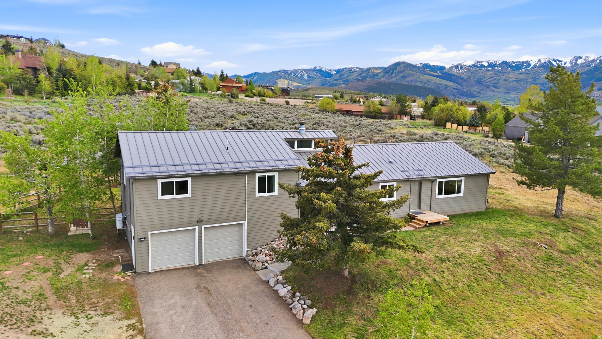2+ acres of Spacious Mountain Living with Panoramic Ski Resort & Endless Possibilities      Set on more than 2.3 acres in Highland Estates, this thoughtfully updated mountain retreat captures panoramic views stretching from Deer Valley Resort to Utah Olympic Park. It blends modern comfort and convenience with the space, flexibility, and outdoor lifestyle buyers seek in Park City.  At the heart of the home is a stunning chef's kitchen featuring custom soft-close cabinetry, quartzite countertops and backsplash, and a beautiful 48-inch double-oven gas range with commercial hood and pot filler. The open-concept living, dining, and kitchen areas have been elevated with new hardwood flooring, while the windows frame the surrounding ski resort and mountain views.  Additional upgrades include updated windows, mini-split heating and cooling systems in the living room and 3 of the bedrooms, new carpet throughout, fresh interior and exterior paint, updated lighting, fiber internet, water softener, and a freshly stained back deck with expansive mountain views, and covered pergola for year-round outdoor enjoyment.  The adaptable floor plan includes a separate entrance ideal for guest quarters or a mother-in-law suite.  Outside, the property offers abundant parking for RVs and recreational vehicles, a custom matching 160-square-foot shed, trees, and ample room to enjoy the mountain lifestyle. The acreage add the rare potential to build a barn, large garage and other structures. Located just minutes from Round Valley trails, Trailside amenities, dining, and shopping, this move-in-ready property offers the rare combination of acreage, views, updates, and convenience in Park City.