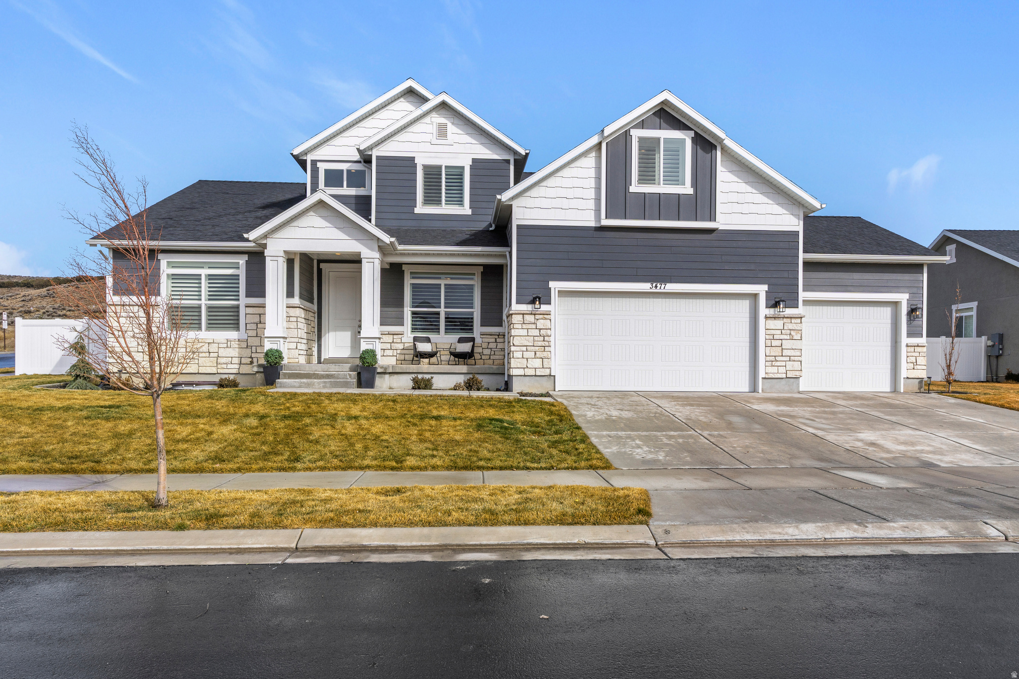 Positioned on a corner lot near the Saratoga Springs border, this 2022-built Eagle Mountain home offers over 4,500 square feet, dramatic two-story ceilings, and move-in ready space without the wait of new construction. Just off the entry, a dedicated main-level office or den offers flexible space for remote work, a sitting room, or formal dining. Expansive windows fill the great room with natural light, highlighting the soaring ceilings and open floor plan. The kitchen features white cabinetry, granite countertops, stainless steel appliances, and generous island seating, seamlessly connected to the main living space for everyday function and gathering. The main-level primary suite provides privacy and convenience, complete with a soaking tub, separate glass shower, dual vanities, and an oversized walk-in closet. Window coverings throughout include plantation shutters and custom roller shades. Upstairs offers four additional bedrooms plus a versatile bonus room ideal for a loft, playroom, office, or media space. The unfinished basement provides room to expand and future flexibility. Outside, the fully fenced flat backyard includes an extended paver patio, built-in gas fire pit with seating, and gas hookup for grilling - offering functional outdoor living and usable space that can be hard to find in the area. The three-car garage and extended driveway provide ample parking and storage. Located just minutes from The Ranches Golf Course, neighborhood parks, trails, and improved highway access toward Silicon Slopes. No HOA.
