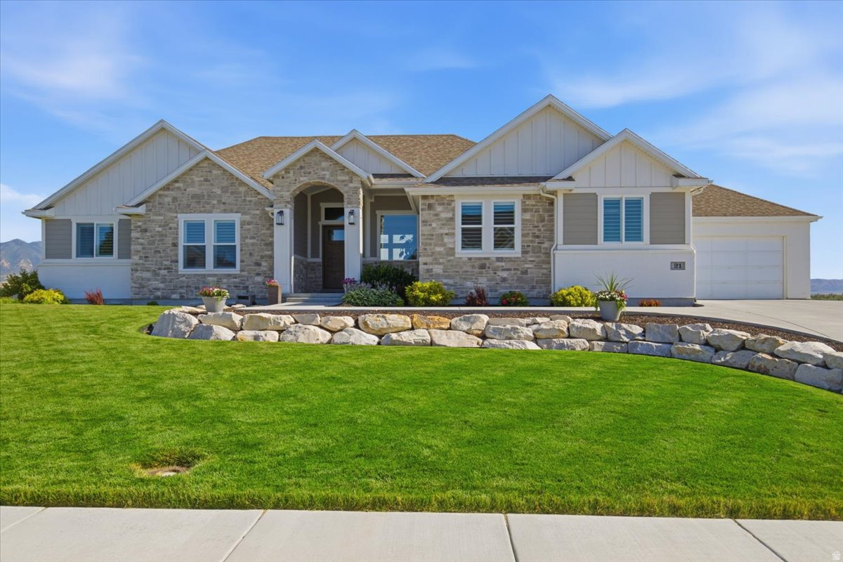 Live at The Pier-Stansbury Park's exclusive gated wakeboard-lake community, where waterfront living, recreation, and remarkable views come together. This exceptional rambler sits on the water with its own private beach and sweeping, unobstructed views across the Tooele Valley toward the Oquirrh and Stansbury Mountains. Expansive windows capture the scenery from nearly every angle, while the upper deck and lower patio provide outstanding spaces for entertaining, relaxing, and enjoying unforgettable sunrises and sunsets.  Inside, soaring 12-foot ceilings in the entry and family room, a 10-foot dining-room ceiling, and 9-foot ceilings throughout the rest of the home-including the basement-create an open, impressive feel. Four fireplaces, including three gas and one electric, add warmth and character throughout. The main kitchen features a large hidden pantry with a convenient garage-to-pantry "Costco door," while the fully finished walkout basement includes a complete second kitchen with double ovens, generous gathering space, and a large exercise or flex room.  The primary suite offers a spacious walk-in closet and an oversized dual-head shower with a view window overlooking the surrounding landscape. A beautifully positioned office also takes advantage of the views and includes a built-in safe with additional storage.  Storage is exceptional, with more than 1,000 square feet of dedicated space, including a large cold-storage room. The extra-wide and extra-deep four-car garage includes hot- and cold-water taps, and the oversized driveway provides abundant parking.  The outdoor setting is equally impressive, with a private beach, full landscaping, rock walls and stairs, flower gardens, a garden area, automatic sprinklers, permanent trim lighting on the front and rear of the home, and roof de-icing elements along the front roofline. Kayaks, paddleboards, and a paddleboat make it easy to enjoy the lake, and the $22,000 Bullfrog hot tub is included. Select furnishings may also be available separately.  This is more than a home, it is a rare opportunity to enjoy luxury, recreation, privacy, and panoramic waterfront views in one of Stansbury Park's most distinctive communities.  Buyer is advised to obtain an independent measurement.    Square footage figures are provided as a courtesy estimate only and were obtained from building plans.  Buyer is advised to obtain an independent measurement.
