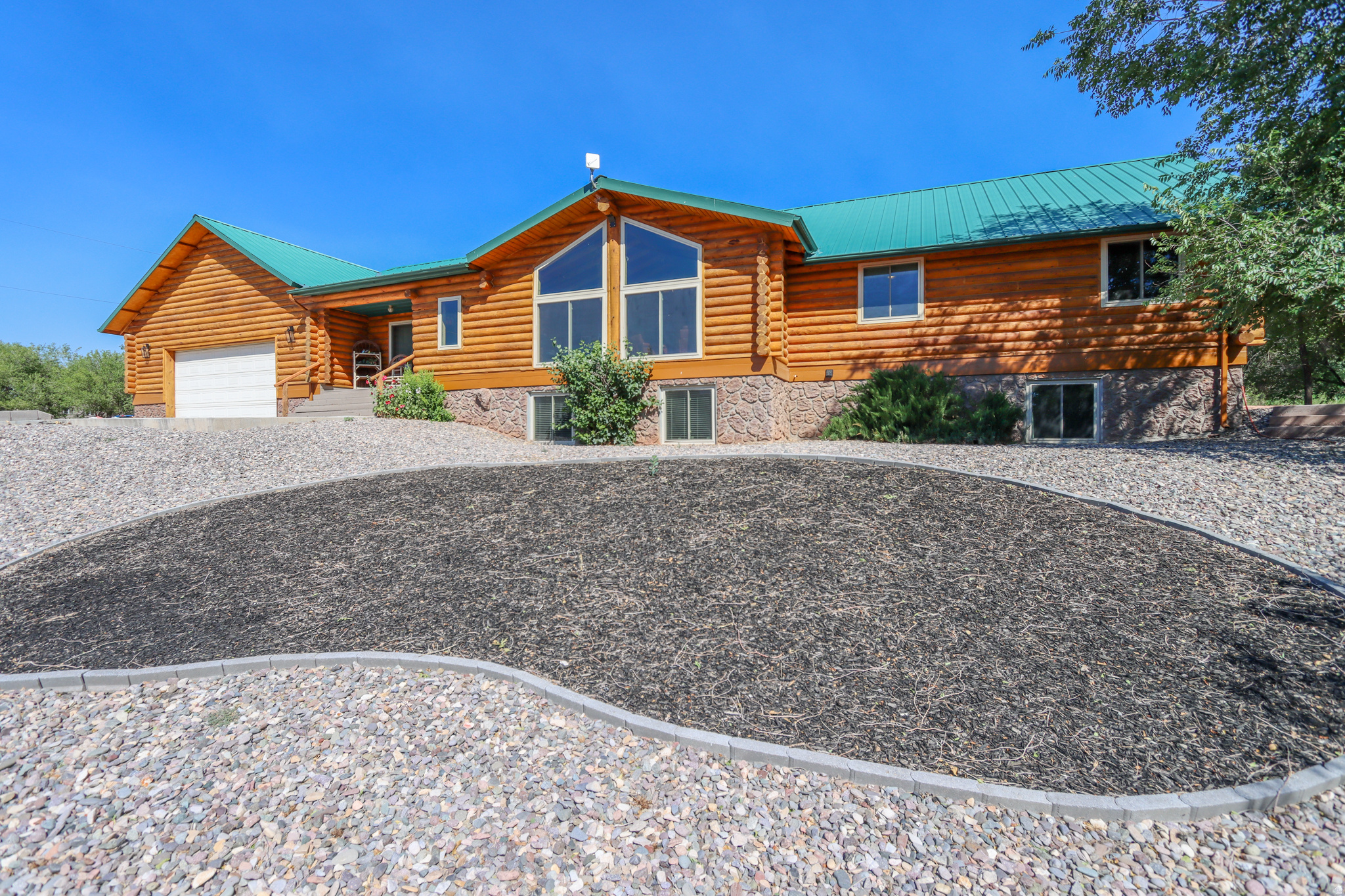 Beautiful, luxurious log home with views, acreage, and a dome greenhouse. Many updates! Enjoy a relaxing setting with a mature trees, a treehouse, and an ephemeral stream fed by the Monroe Canal. The home's log exterior was professionally refinished in 2025. Inside, a vaulted living room welcomes visitors and serves as a beautiful focal point. Large window open up to views over the valley. Just off the living area is an impressive chef's kitchen. Home cooks will love new cabinets and granite and steel countertops. A full basement has a separate entrance and a kitchenette, which would work well as an apartment or short term rental. A large attached garage and dedicated storage room provides plenty of parking, storage, and workshop space. The home includes a separate private well that could be converted for livestock watering or farming. The dome greenhouse seams were recently re-taped, and all furniture, tools, and plants inside of it are included. Turn-key property with flexible living potential, room to grow, and many modern upgrades.