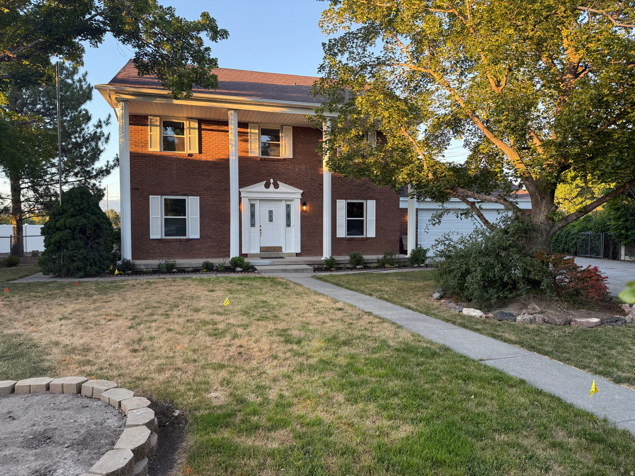 Located on a quiet cul-de-sac a block away from the Jordan River Parkway, you'll find this classic two-story beauty with timeless curb appeal! Framed by stately white colonial columns and charming red brick, this home makes a memorable first impression.  Inside, you'll find fresh paint, brand-new carpet, and updated electrical, making it move-in ready from day one. The spacious white-on-white kitchen opens to a cozy family room that features a wood-burning fireplace. Enjoy the flexibility of both a formal living room and a formal dining room that could easily serve as a home office. The showstopper is the enormous primary suite, complete with one of the largest en-suite bathrooms and walk-in closets you'll find-your own private retreat with room to spare! Need storage? This home delivers with a big butler style pantry, huge cold storage area, a large backyard shed, and a brand-new garage. Outside, there's plenty of room for all your toys with RV parking, plus a basketball hoop for hours of fun. The backyard has already been graded and is a blank canvas, ready for its new owners to create the outdoor oasis they've always imagined. Clean, spacious, and ready for immediate occupancy-this is a home you'll want to see in person!