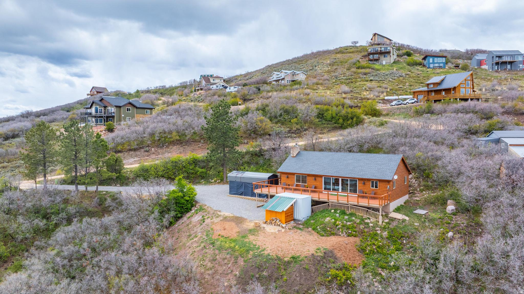 Beautifully remodeled mountain retreat surrounded by nature with spectacular views of Rockport Reservoir and the Uinta Mountains! This charming cabin features soaring vaulted ceilings, expansive windows, and an incredible enclosed sunroom designed to capture the breathtaking scenery year-round-perfect for relaxing, entertaining, or simply soaking in the peaceful mountain setting. The spacious feel continues outdoors with a massive 694 sq. ft. wrap-around deck offering even more room to enjoy the stunning views, plus an additional 126 sq. ft. loft space. With approximately 9,300 gallons of total water storage capacity-more than enough for the winter months-this home is as practical as it is beautiful. Enjoy efficient heating with a gas furnace and fireplace/stove insert, while taking advantage of nearby boating, fishing, biking, skiing, hiking, and everything the Wasatch Back has to offer, including the dining and nightlife of Park City. The property has seen extensive upgrades since 2023. Major improvements include a new heater with an ultraviolet air filter, Nest thermostat installation, a full roof replacement with new sheathing and shingles, upgraded attic and sunroom insulation increased to approximately R49, and a new refrigerator. Additional exterior enhancements include oak brush removal near the deck, a tiered parking system with a 24x10 RV cover, and expansion of the northeast side of the property by about 1,000 square feet with added dirt and leveling. In 2024, a stone wall widened the driveway, gravel was added throughout, new front and downstairs doors with improved R-value were installed along with new storm doors, the septic system was cleaned, and a woodshed with capacity for about two cords of wood was built. In 2025, a 10x18 one-car covered carport was added, water tanks were relocated and protected with sturdy watershed structures, and electrical wiring with heat tape was installed to help prevent freezing. In 2026, the gravel driveway work was completed and new carpet was installed in the living room. Whether you're looking for a full-time residence or the perfect mountain getaway, this one is not to be missed!