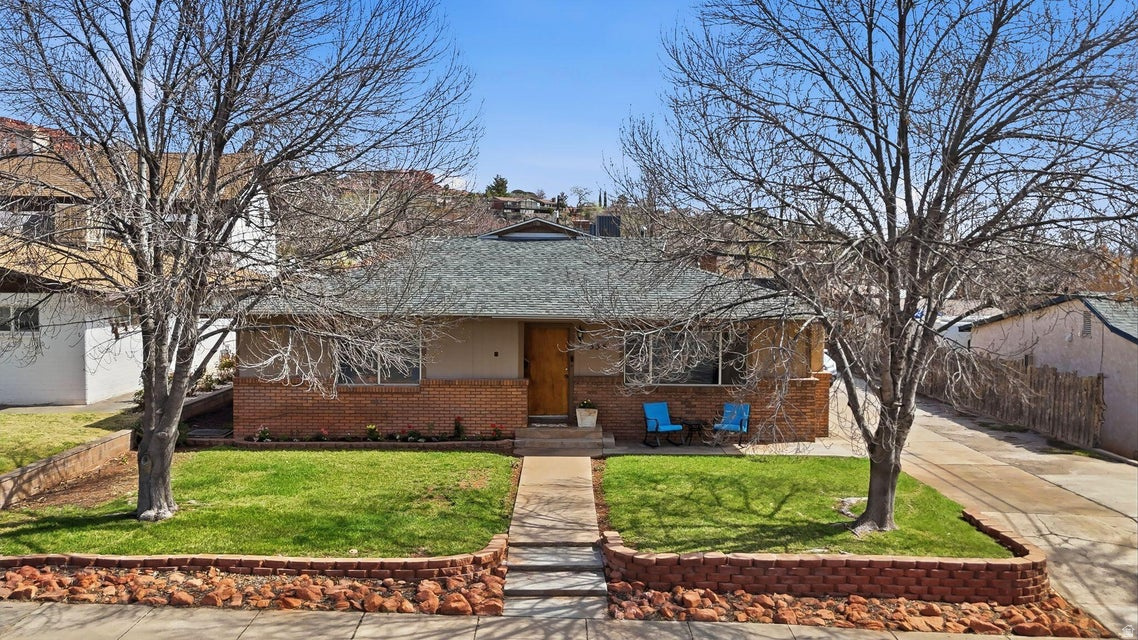 Located just off Diagonal Street in the heart of downtown St. George, this unique property offers an unbeatable combination of charm, location, and investment potential. Within walking distance to parks, shopping, restaurants, and other downtown amenities, the location provides both convenience and lifestyle appeal. Originally built in 1951, the home has been thoughtfully expanded over the years with the addition of a spacious primary bedroom and large living room, bringing the total living space to approximately 2,310 square feet. The home features large bedrooms, two cozy wood-burning stoves, and a warm brick exterior that adds character and durability. Recent updates include improvements to the plumbing, an updated bathroom, and a newer HVAC system, providing comfort and peace of mind. What truly sets this property apart is the impressive 0.40-acre lot, an extremely rare find this close to downtown St. George. Mature trees provide shade and privacy, while the large driveway offers plenty of parking for residents, guests, or tenants. The property also includes a detached shop or one-car garage, perfect for storage, hobbies, or workspace. For investors or those looking to maximize value, the property presents exceptional opportunity. According to city allowances, up to two Accessory Dwelling Units (ADUs) may be permitted on the property, creating the potential for multiple rental streams or multigenerational living. With the generous lot size and flexible layout, there are many possibilities to expand the property's income potential. Whether you're looking for a unique downtown residence with space to grow, an investment property with strong rental potential, or a rare large lot in a highly desirable location, this St. George property offers opportunities that are increasingly hard to find.