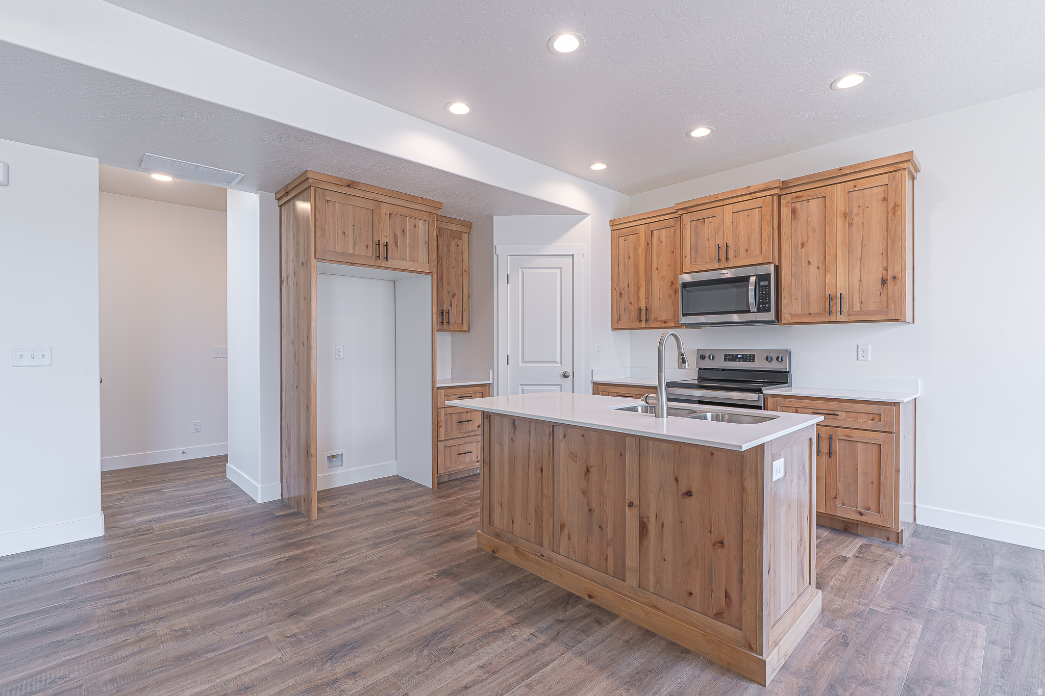 Beautiful move-in ready end-unit townhome featuring designer wood-tone cabinetry, quartz countertops, two-tone paint, and a spacious primary suite with tray ceiling. Extra windows fill the home with natural light, while warm finishes and thoughtful details create a welcoming space that feels more like a home than a typical townhome.