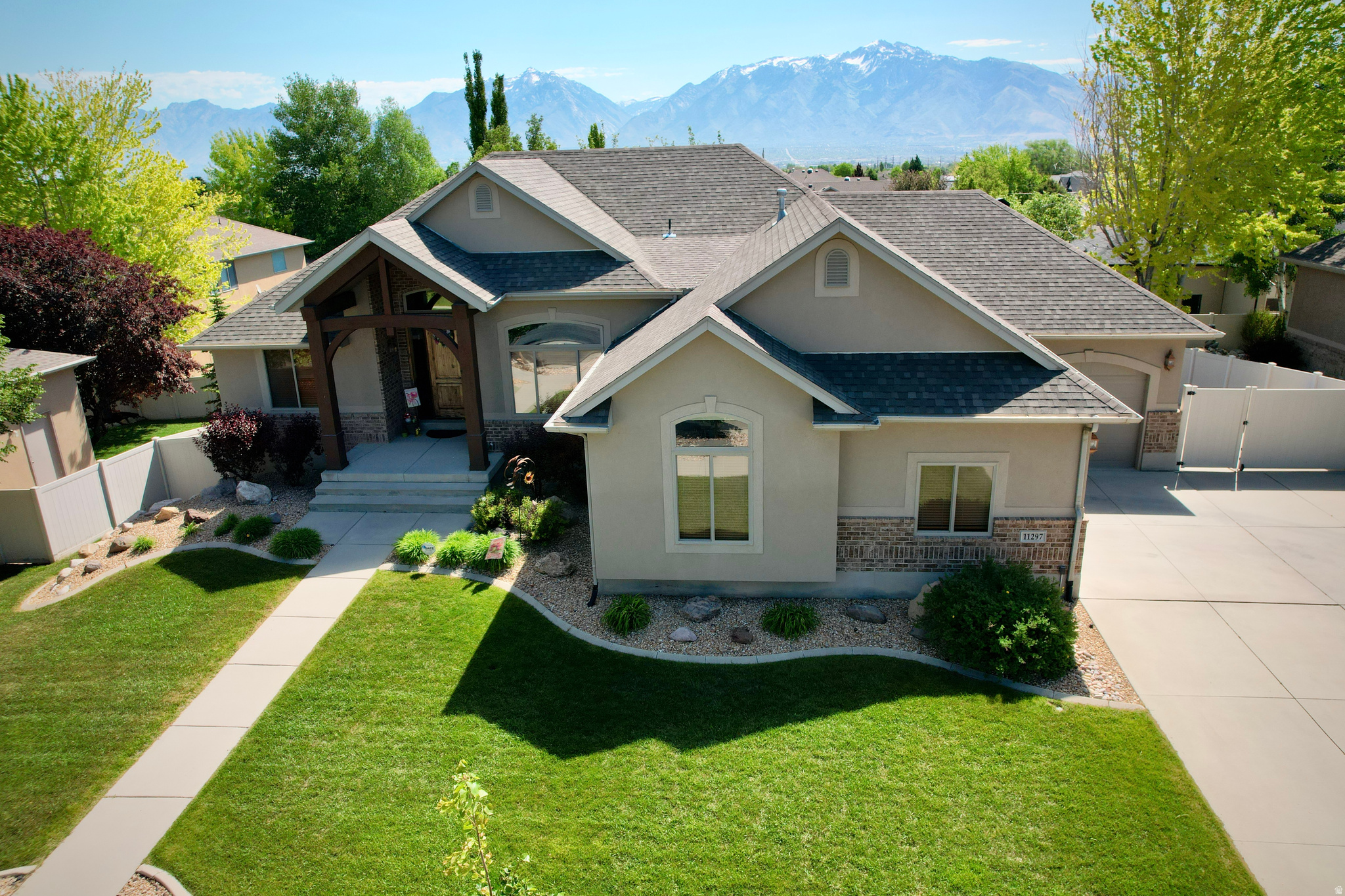 Showings begin on Saturday @ Open house Saturday the 16th from 10:00-1:00. Immaculate, original owner, custom home offering exceptional space, mountain views, quality craftsmanship, and outstanding attention to detail throughout. This pre-inspected 3,984 square foot, 5-bedroom, 3-bath home has been owned and maintained by an engineer to exacting standards - a completed pre-listing inspection confirmed zero deferred maintenance items, giving buyers solid peace of mind. The moment you step through the solid knotty alder front door, soaring vaulted ceilings, hardwood floors, and a sweeping wrought iron and wood staircase set the tone. The open-concept main floor flows from the grand entry through the great room and into the kitchen and dining areas, anchored by a dramatic floor-to-ceiling stacked stone corner fireplace and framed by large arched windows with beautiful mountain views. The kitchen features knotty alder cabinetry, a large wraparound peninsula with bar seating, newer stainless appliances, recessed lighting, and tile floors, opening directly to a bright dining nook with a French door leading to the covered upper deck - an ideal setup for entertaining and everyday living. The primary suite includes a spacious walk-in closet with organizers and a well-appointed en suite with a double vanity, soaking tub, and a separate glass-enclosed tile shower. The main floor hall bath is finished with granite countertops and a glass-door walk-in shower. A generous main-floor laundry room with full knotty alder cabinetry enhances the home's exceptional functionality. The fully finished walkout basement dramatically expands the living space, featuring a second stacked stone corner fireplace, a full basement apartment with its own kitchen and entrance - perfect for multigenerational living or rental income - cold storage, and a pool table that is included with the home. The backyard is fully fenced and features a covered upper deck, a lower concrete patio, a swingset, raised garden beds, and mature trees. Additional highlights include a 5-year-old Trane two-stage 95% efficiency HVAC system, a whole-home water softener, oil-rubbed bronze fixtures, and closet organizers in multiple bedrooms. A new 50-year roof was installed a year ago (Transferable warranty). This is a rare opportunity to purchase a large, well-built home with complete confidence. The pre-listing inspection is available at all showings. If the square footage or acreage of the property or improvements is of material concern to the buyer, the buyer is responsible for verifying the square footage/acreage measurements and improvements to the buyer's satisfaction.