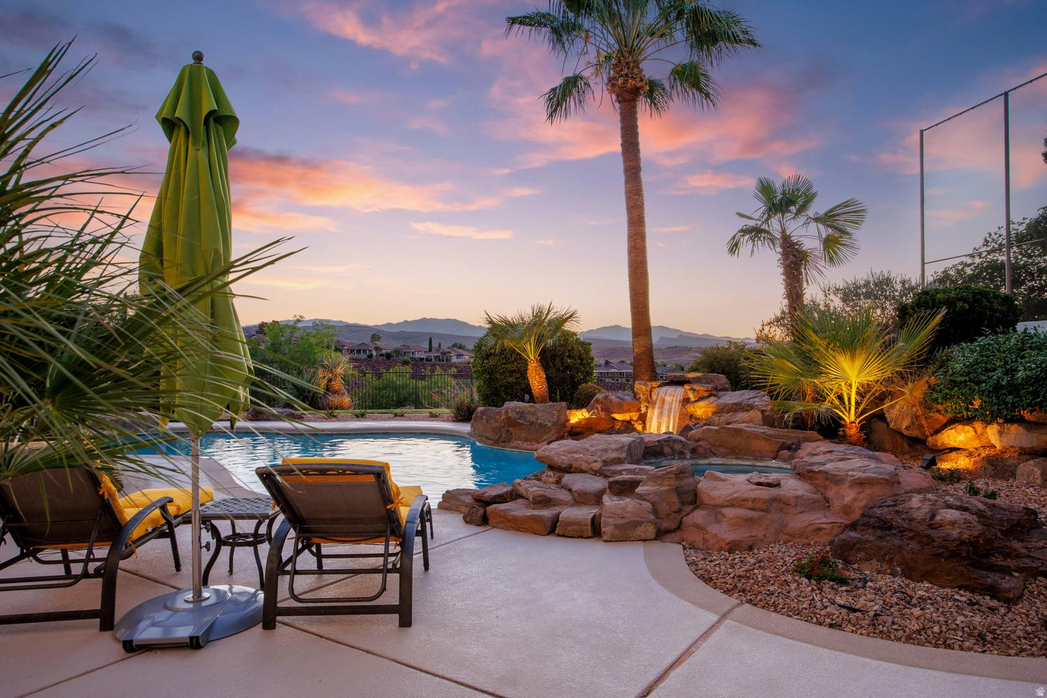 Resort-style living above the Southgate Golf Course. This fully remodeled estate offers golf course and mountain views from a private pool and spa, all set at the end of a cul-de-sac on nearly half an acre with no HOA. Inside, wall-to-wall 8-foot windows capture sweeping views to the north and west. Open living spaces feature wide-plank flooring, designer fixtures, Cristallo Juliet - a luxurious, rare Brazilian natural stone- fireplace surround, wall treatments, and airy 12-foot ceilings. The gourmet kitchen pairs quartz countertops and a large island with white Shaker cabinets, stainless appliances, and pantry storage, complete with a powered dumb waiter. A breakfast bar and dining area offer flexible hosting and everyday meals, with direct access to the terrace with a built-in grill. The whole space opens up to a view deck for effortless outdoor living. Also on the main level, the primary suite includes balcony access, an incredible spa-like bath, and a large walk-in closet with floor-to-ceiling custom organizers. Two versatile offices round out this level. Downstairs, the walk-out lower level adds a second kitchen, another living area, and four more bedrooms, three of them en-suite. A hobby room gives you space to gather or create to your hearts content. With nearly 5,000 total square feet, the layout adapts easily to multigenerational living or hosting guests. Outside, the backyard is built for relaxing and entertaining. Take a dip in the pool or settle into the spa and listen to the waterfall while sunset colors spread across the mountains. A modern metal louvered pergola and covered patios give you shade, two built-in BBQs make grilling easy, and tropical palms and stone hardscape set the mood. The fenced yard leaves room for pets and play. Additional conveniences include a three-car garage with resin chip epoxy flooring, a water softener, central vacuum, smart watering system, smart thermostats, Sonos home entertainment and abundant storage.