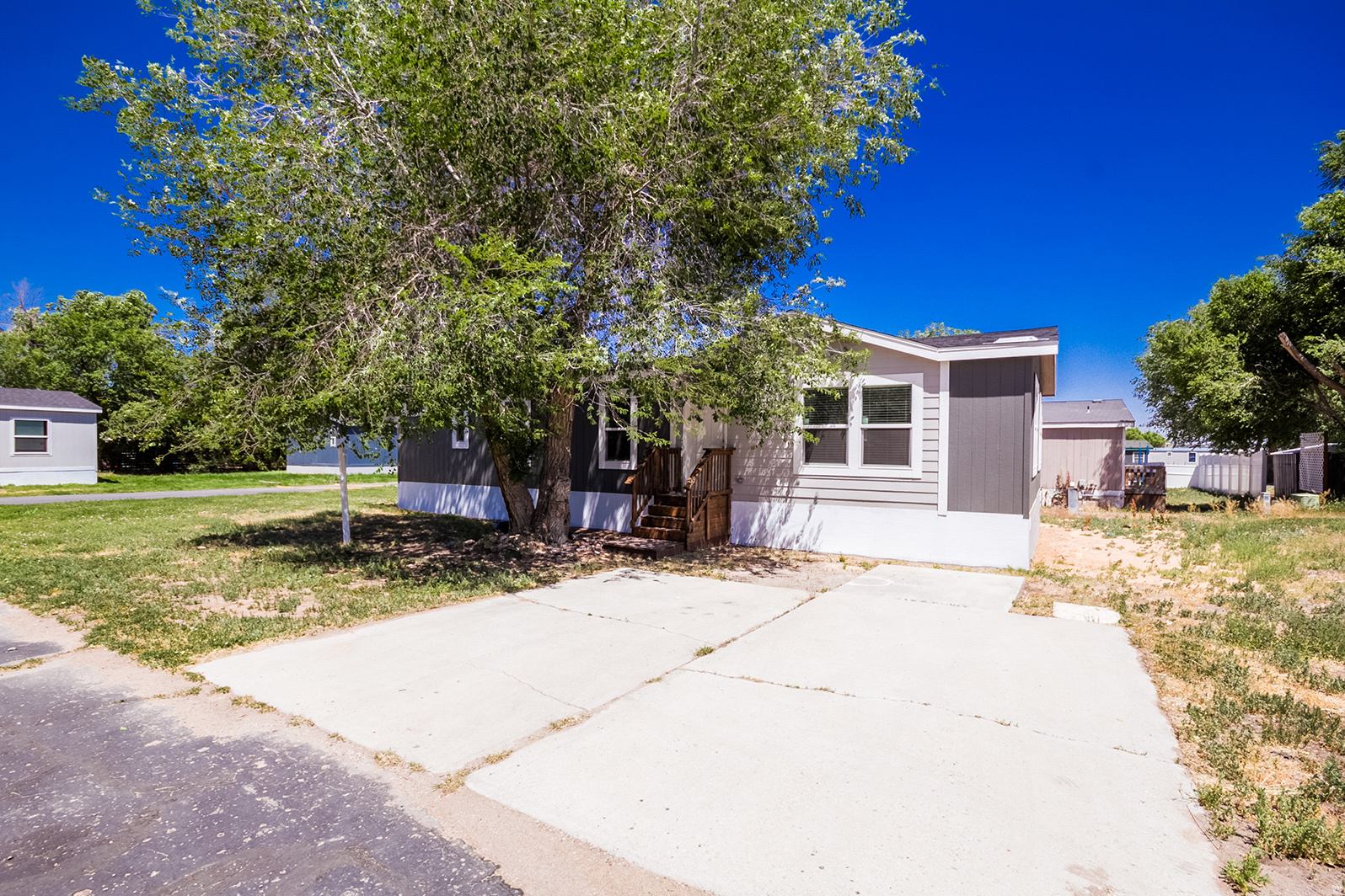 This brand-new home is just as beautiful on the inside as it is on the outside and is available in East Meadows Mobile Home Park, conveniently located in downtown Vernal, Utah. Offering 1,420 square feet of living space, this home features 3 bedrooms and 2 bathrooms, along with beautiful cabinetry, stylish flooring, and stainless-steel appliances. The bright white cabinetry creates a clean, modern feel throughout the home. The spacious primary suite includes a luxurious ensuite bathroom with double sinks, a walk-in closet, a large walk-in shower with a built-in seating area, and a private commode. Additional storage, upgraded lighting, and thoughtful design details make this home both functional and inviting. Don't miss the opportunity to own this stunning, never-lived-in home in a desirable location close to shopping, dining, and local amenities. Financing is available with a small down payment and low monthly payments. Home must remain in the park.