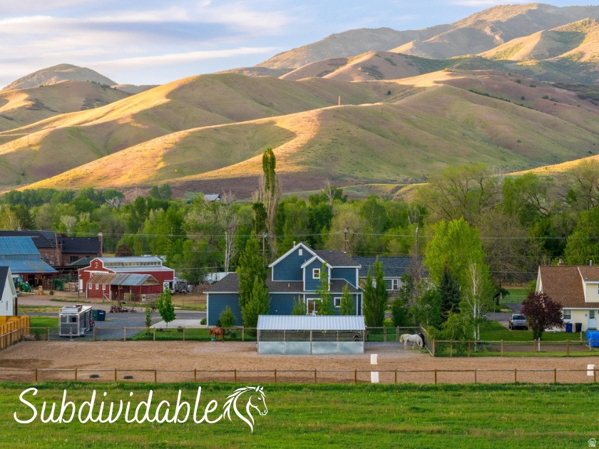 Welcome to peaceful Morgan Valley living, where quiet country roads, breathtaking mountain views, and the simple beauty of life with horses create a lifestyle that feels worlds away from the rush of the city. Nestled on a serene 1.05-acre setting along a quiet lane, this custom-built equestrian property offers the perfect blend of small-town charm, modern comfort, and thoughtfully designed horse amenities beneath Utah's stunning open skies. Adding even more value and future opportunity, the property also offers subdivision potential with the ability for a flag lot and possible additional residence, creating flexibility for investment, multigenerational living, or future expansion. It is also a wonderful opportunity to enjoy a true small-town agricultural lifestyle with space and amenities ideal for 4-H, FFA, or raising animals. Morgan Valley is known for its welcoming community, scenic beauty, and endless outdoor recreation. Enjoy nearby hiking trails, including the popular trail to the iconic "M," where breathtaking panoramic views overlook the valley below. World-class fishing along the nearby Weber River, tubing adventures downstream, a scenic 18-hole golf course, and peaceful campgrounds where bald eagles are often spotted all contribute to the incredible lifestyle this area offers. Living here truly feels like stepping into a place where every day feels like a retreat in nature. Morgan's charming Main Street offers local favorites including a beloved dairy and mercantile featuring fresh milk, cream, butter, ice cream, farm fresh eggs, and local honey. The town is also home to several delicious mom-and-pop restaurants, local gathering spots, and small-town entertainment that add to the warmth and charm of this thriving rural community. Imagine mornings spent riding along Morgan's scenic country roads as the mountains glow with sunrise, or loading up the trailer for a short drive to nearby trailheads offering endless riding adventures through Utah's breathtaking backcountry. Built in 2019, this beautifully designed 4-bedroom, 3-bath home is surrounded by mature trees, flowering perennial gardens, and a peaceful park-like atmosphere. Expansive windows flood the home with natural light while perfectly framing the surrounding mountains and pasture views. The inviting living room features a beautiful gas log fireplace, while the kitchen blends elegance and functionality with granite countertops, custom soft-close cabinetry, stainless steel Whirlpool appliances, a gas range, subway tile backsplash, and a picturesque sink view overlooking the pasture and Wasatch Mountains. The main-level primary suite offers peaceful privacy with dual closets and an ensuite bath, while upstairs you'll find two spacious bedrooms filled with beautiful natural light and a full bathroom thoughtfully designed for comfort and functionality. The basement includes a large family room, additional bedroom, full bath, and cold storage. Designed with the equestrian lifestyle in mind, the outdoor amenities create the perfect setup for both horse and rider. The professionally prepared sand footing arena with box entry provides an ideal space for riding and training, while the four-stall barn with oversized 12x16 stalls includes both electricity and water for added convenience and functionality. Fully fenced paddocks, generous RV and trailer parking, and an included water share complete this truly horse-ready property. Whether you envision peaceful evenings under star-filled skies, horses grazing outside your windows, or a quieter life rooted in nature and open space, this exceptional property captures the very best of country living in beautiful Morgan Valley. Square footage figures are provided as a courtesy estimate only. Buyer is advised to obtain an independent measurement.