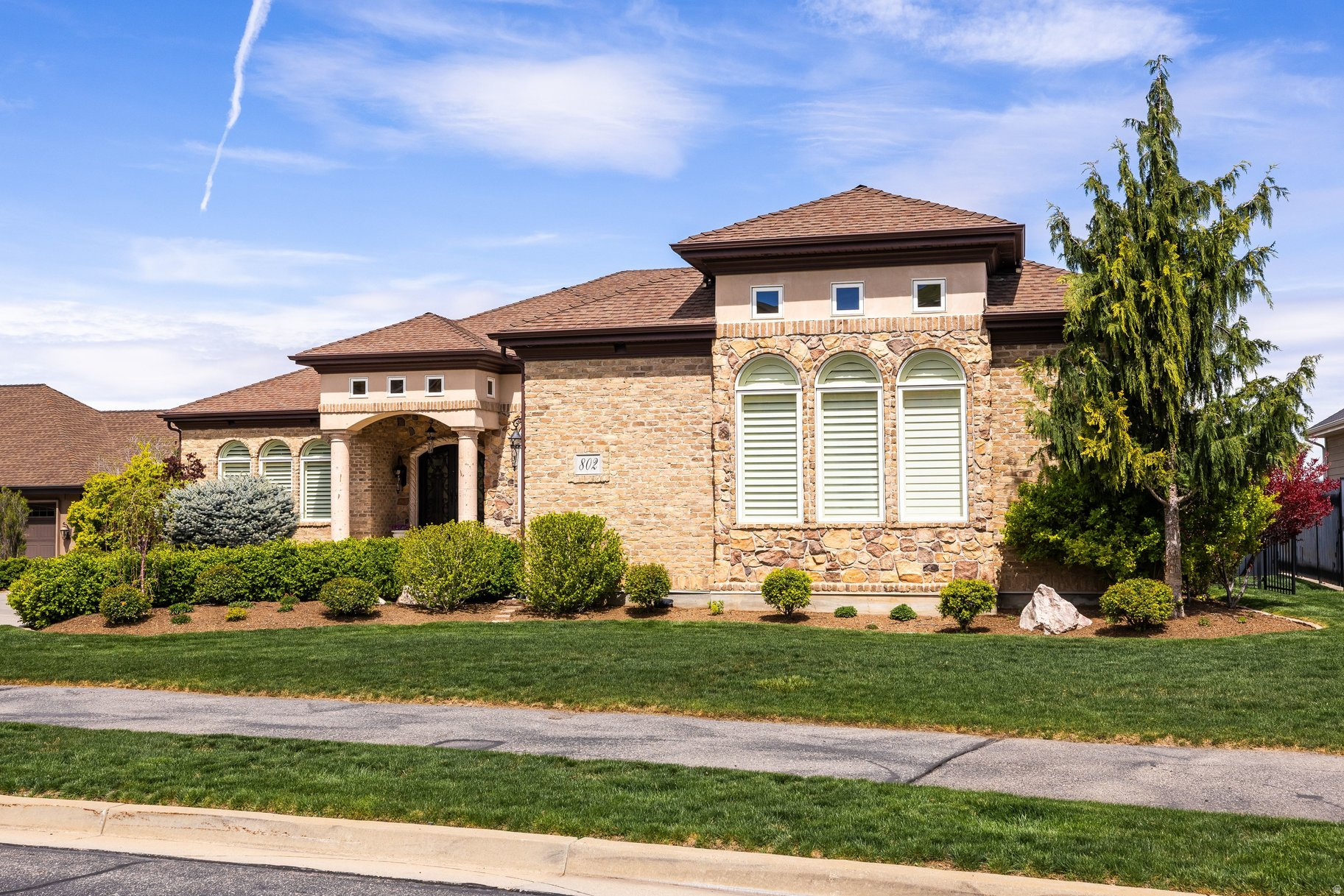 Exceptionally maintained custom home with a highly functional floor plan and timeless all-brick and stone exterior. Recent updates include a new roof, updated appliances, garage doors, shades, and main HVAC-offering peace of mind and modern comfort. Designed for effortless main-floor living, this home features two bedrooms, a den, formal dining, a spacious great room, and a beautifully appointed kitchen with breakfast area and bar. Step into your own private sanctuary patio, perfectly accessible from the primary suite, den, and kitchen. The lower level expands your lifestyle with a theater room, fitness space, three additional bedrooms, a second kitchen, and another generous great room-ideal for entertaining or multi-generational living. Ample storage throughout and a three-car garage with a dedicated workspace complete the home. Located in Eaglepointe Estates in North Salt Lake, enjoy the perfect blend of suburban comfort and urban accessibility, with nearby parks and a vibrant, connected community.