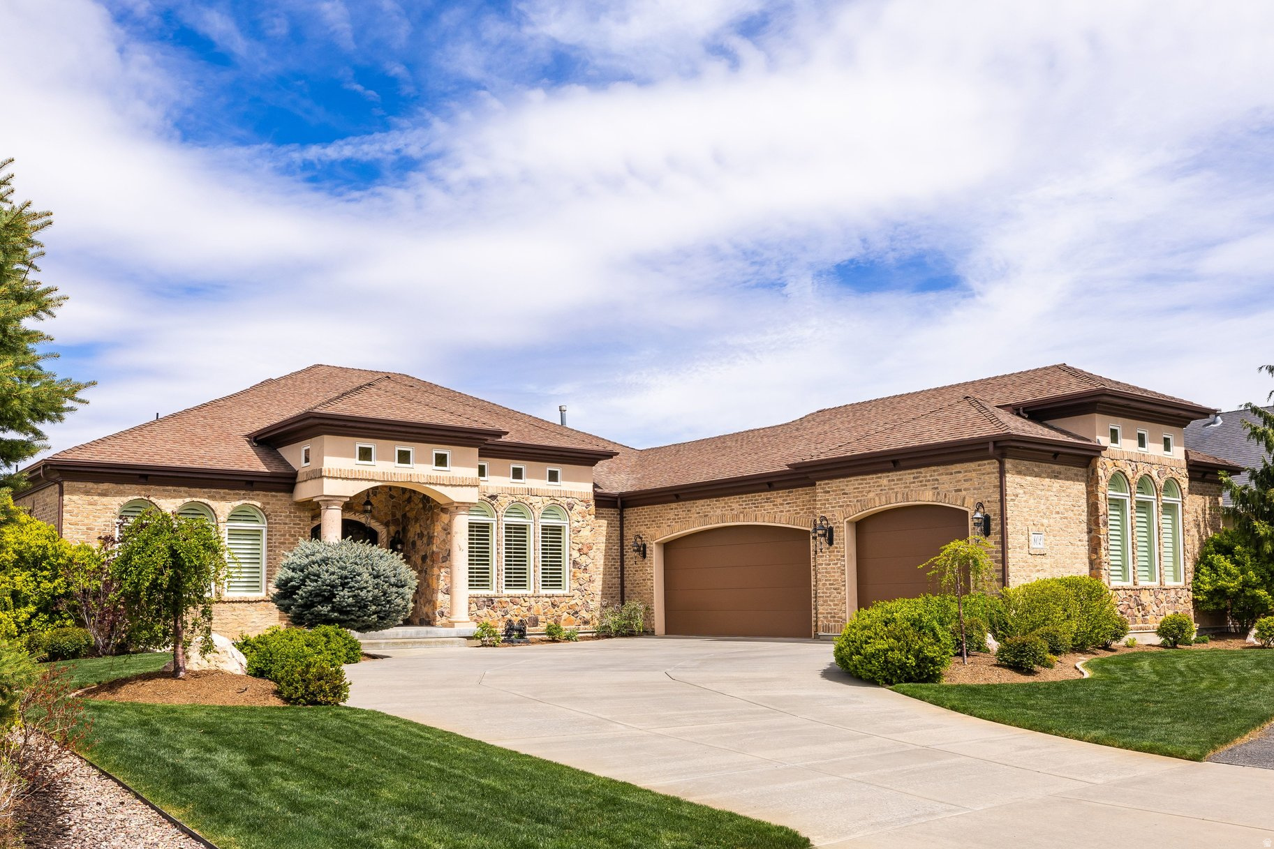 Recent updates include a new roof, updated appliances, garage doors, shades, and main HVAC, while the timeless all-brick and stone exterior offers peace of mind and lasting curb appeal. Exceptionally maintained, this custom home features a highly functional floor plan designed for effortless main-level living. The main floor includes two bedrooms, a den, formal dining room, spacious great room, and a beautifully appointed kitchen with a breakfast area and bar. Step into your own private sanctuary patio, conveniently accessible from the primary suite, den, and kitchen.  The lower level expands your lifestyle with a theater room, fitness space, three additional bedrooms, a second kitchen, and another generous great room-ideal for entertaining or multigenerational living. Ample storage throughout and a three-car garage with a dedicated workspace complete the home.  Located in Eaglepointe Estates in North Salt Lake, this home offers the perfect blend of suburban comfort and urban accessibility, with nearby parks and a vibrant, connected community.