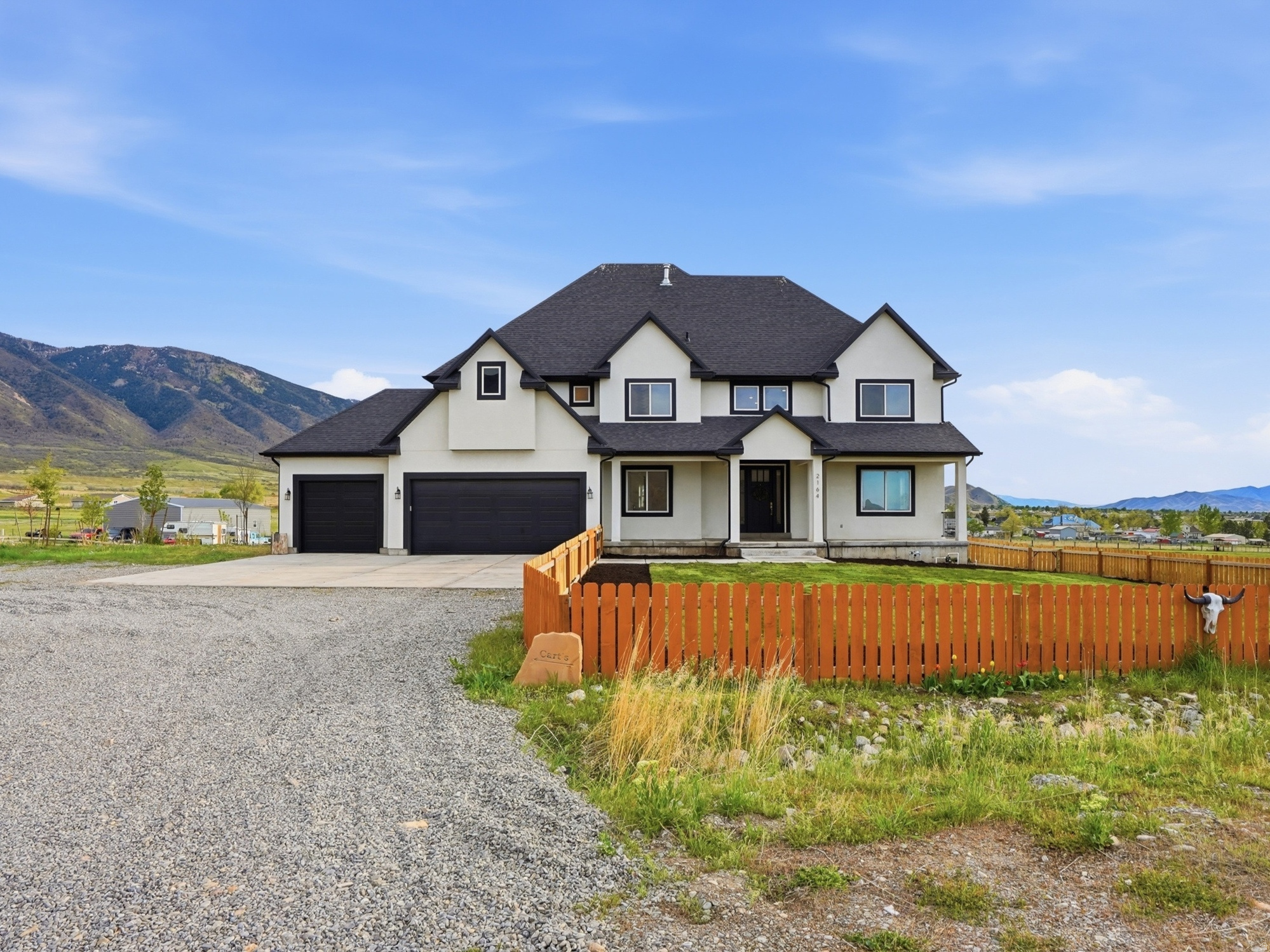 CUSTOM-BUILT | WATER SHARE | ACREAGE | VIEWS - Set on 4.70 acres along the east bench of Tooele, this custom-built home offers a rare combination of space, privacy, and freedom, all within a convenient drive to the Salt Lake Valley. From the moment you arrive, the fully fenced front yard and inviting entry create a warm first impression. Inside, a functional entry with a built-in bench welcomes you into flexible spaces that can easily serve as a formal dining room, home office, or cozy sitting area. The thoughtful layout flows effortlessly throughout the home, creating spaces that are both comfortable and ideal for everyday living. At the heart of the home, the expansive kitchen features a large island, abundant cabinetry, a spacious dining area, and direct access to the oversized deck perfect for entertaining or simply enjoying the peaceful surroundings. The adjoining living room is filled with natural light and highlighted by soaring vaulted ceilings that create an open, airy feel. All kitchen and household appliances are included, allowing for a seamless move-in experience. A main-level bedroom and full bathroom provide added flexibility for guests, multi-generational living, or a private workspace. Upstairs, you'll find four additional bedrooms, including a Jack-and-Jill layout and a spacious primary master suite complete with a spa-like bathroom featuring dual vanities, a soaking tub, separate tiled shower, a large walk-in closet, and private balcony access. The unfinished 2,165-square-foot basement offers endless possibilities to create additional living space, a home theater, fitness room, or whatever best fits your lifestyle, along with an impressive amount of cold storage. Step outside and discover what truly makes this property exceptional. Set against unobstructed mountain views, the backyard offers a breathtaking backdrop that you'll be able to enjoy for years to come. With 4.70 acres of usable land, there's room for horses, future outbuildings, recreational space, or simply the privacy and freedom that are becoming increasingly difficult to find. The expansive deck, firepit, and in-ground trampoline create the perfect setting for entertaining, relaxing, and making lasting memories all while taking in some of the best views Tooele's east bench has to offer. The property also includes one Lincoln Culinary water share, providing 25,000 gallons of culinary water per month, with the option to purchase additional water if usage exceeds that amount. Buyer and Buyer's Agent to verify all information. Buyer is advised to obtain an independent measurement.