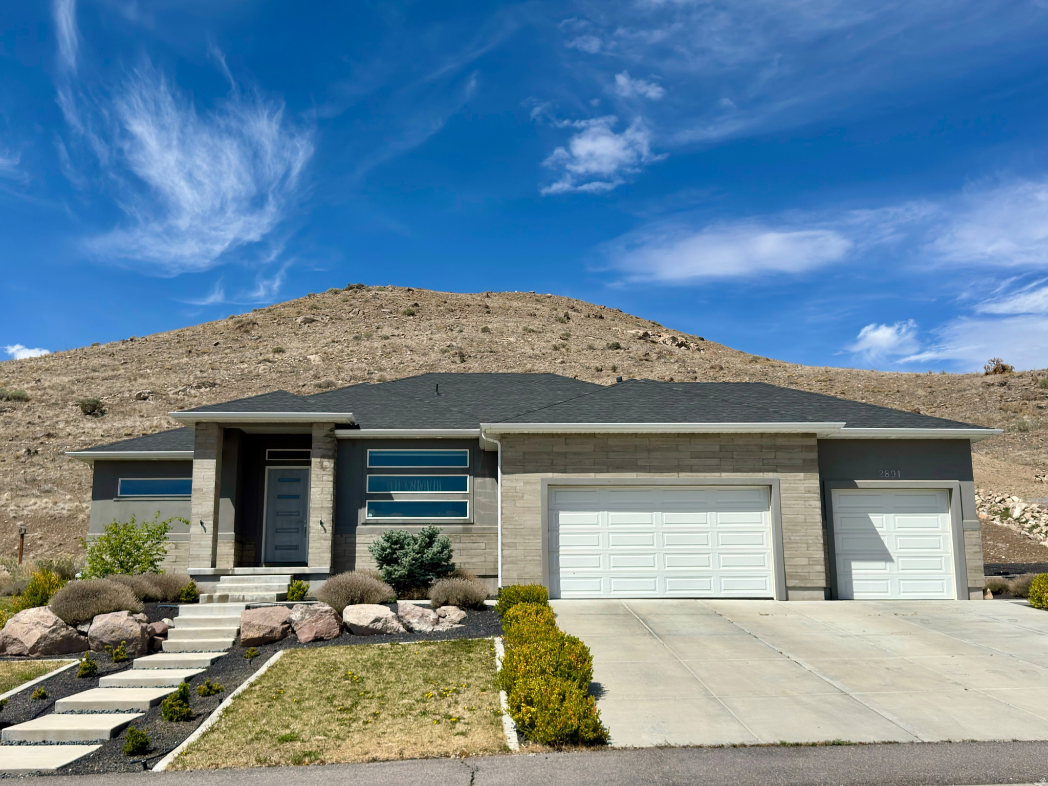 Modern Meadow Ranch rambler boasting panoramic views and clean lines! The vaulted, open-concept living space features a statement fireplace and flows into a chef's kitchen with premium Thermador appliances, a huge island, and a walk-in pantry. Retreat to the main-level primary suite offering a spa bath, soaking tub, and custom closet. Enjoy a fully finished basement, handy mudroom, and a 3-car garage. Set on a .65-acre lot featuring a covered patio, garden area, and a natural, private hillside backdrop. Schedule your showing today!