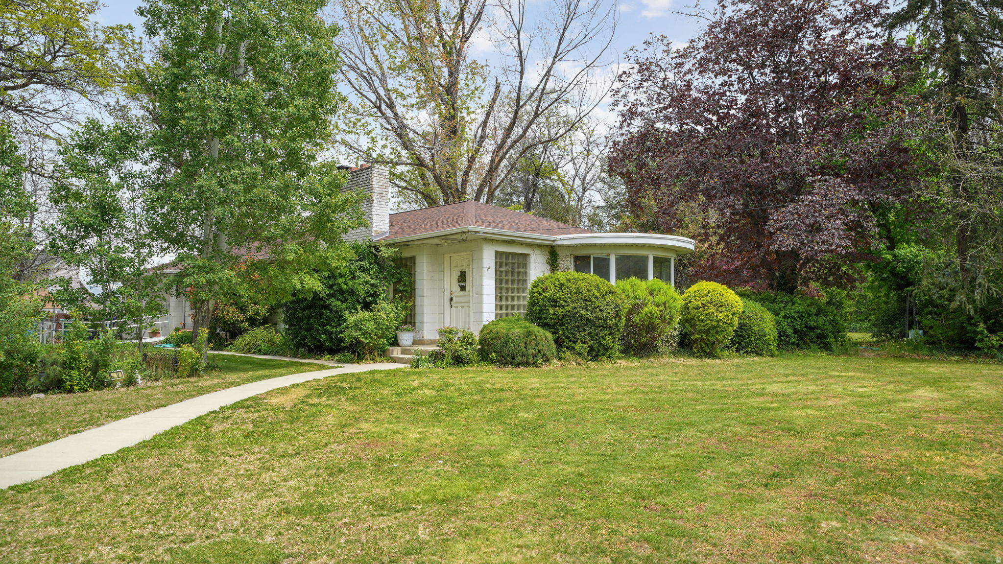 Welcome to this unique opportunity for builders, investors, or families that desire multi-generational living. This property provides a rare opportunity to own over an acre of land in the heart of Sandy! There is a HUGE potential for a small-scale development or for a 2nd home to be built beside the existing home. The massive 2 level garage has a workshop, bathroom, and floor with radiant heat! You could make this your dream home as you remodel it to your own personal taste! Step inside to find a bright and inviting floor plan with abundant natural light and a cheerful South-facing sunroom. There are several large gathering spaces with fireplaces making for cozy family gatherings. The two family rooms, formal dining area, and deck provide the perfect settings for both relaxing and entertaining. The main floor kitchen has an adjoining semi-formal dining area. The basement has an area that can easily be converted into an apartment with a kitchen. Add a private walk-out entrance to the apartment area to make a dedicated mother-in-law apartment. The large, private yard offers room to garden, bar-b-que, or simply unwind cooking hotdogs or marshmallows over the fire pit. There is a serene walking path through your private wooded-area. This location combines the comforts of being nestled in an established neighborhood while also providing quick access to I-15 and 215 commuter routes. It is close to a variety of shopping, dining, parks, and top-rated schools. Buyer to verify all zoning, subdivision, and building possibilities with the city and county. Schedule your showing today! Property sold as-is for seller's convenience.