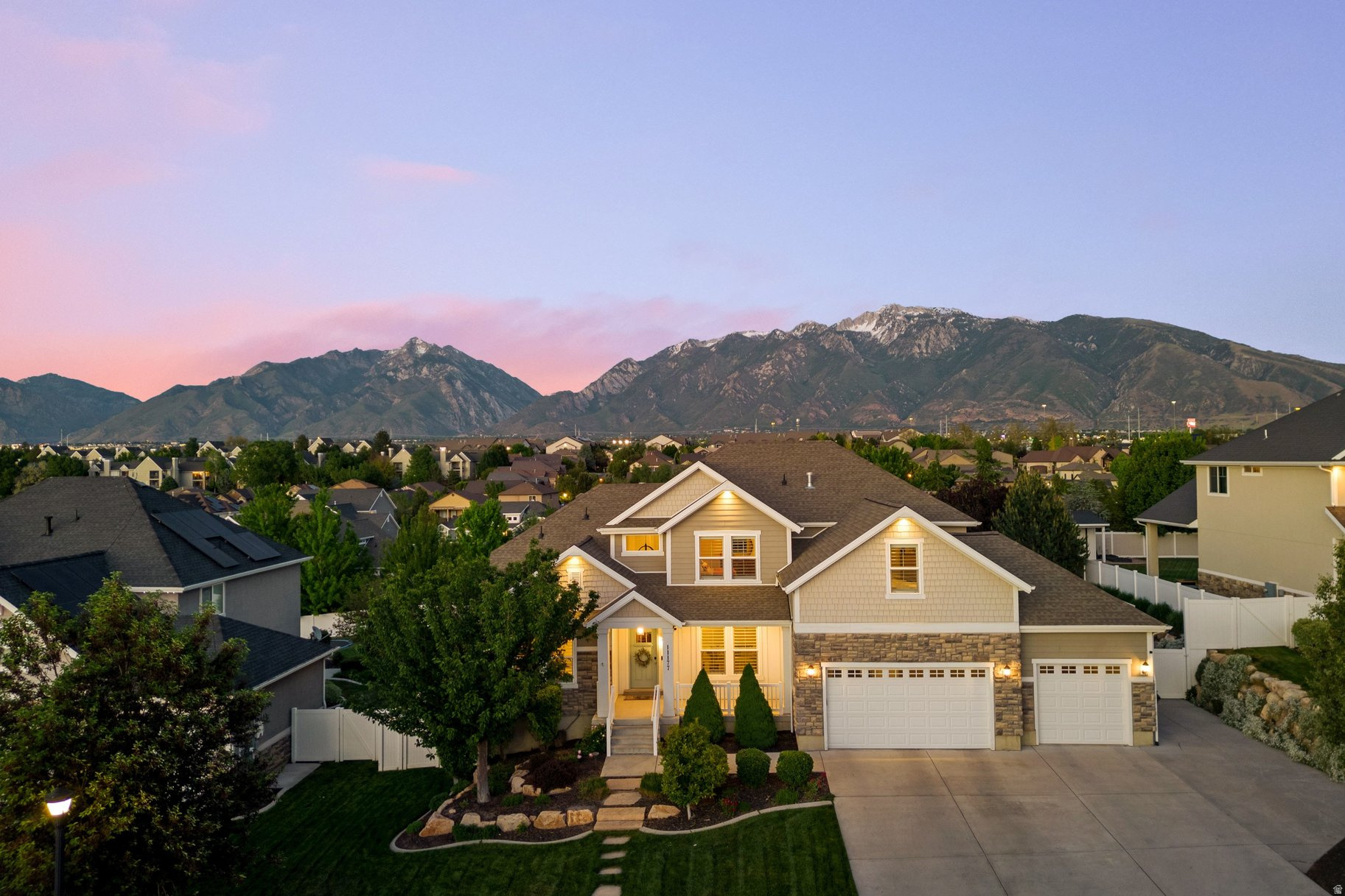 This is the kind of home that changes how you live. Built in 2014 and tucked into a quiet South Jordan neighborhood, with easy access to the freeway and surrounded by lifestyle amenities, this home effortlessly blends expansive indoor spaces with abundant outdoor living. Natural light pours through oversized windows. The backyard becomes another living room. Summer evenings belong on the covered deck beneath mountain sunsets and soft alpenglow along the Wasatch Front. Oak hardwood floors, soaring ceilings, open floor plan, vaulted ceilings, a media room, second kitchen, hot tub, outdoor fire pit, cascading waterfall feature, hammock, basketball court, mature landscaping, and breathtaking mountain views create a property that lives substantially larger than its footprint. The east-facing backyard is a hidden advantage - shaded, comfortable, and designed for long summer evenings outdoors. From morning sunrise to glowing mountain sunsets, every window reminds you why you live in Utah. Thoughtfully upgraded with epoxy garage flooring, exterior holiday trim lighting, professionally designed landscaping, and a detached storage shed large enough for serious storage or vehicle use, this home balances beauty, function, and everyday joy.