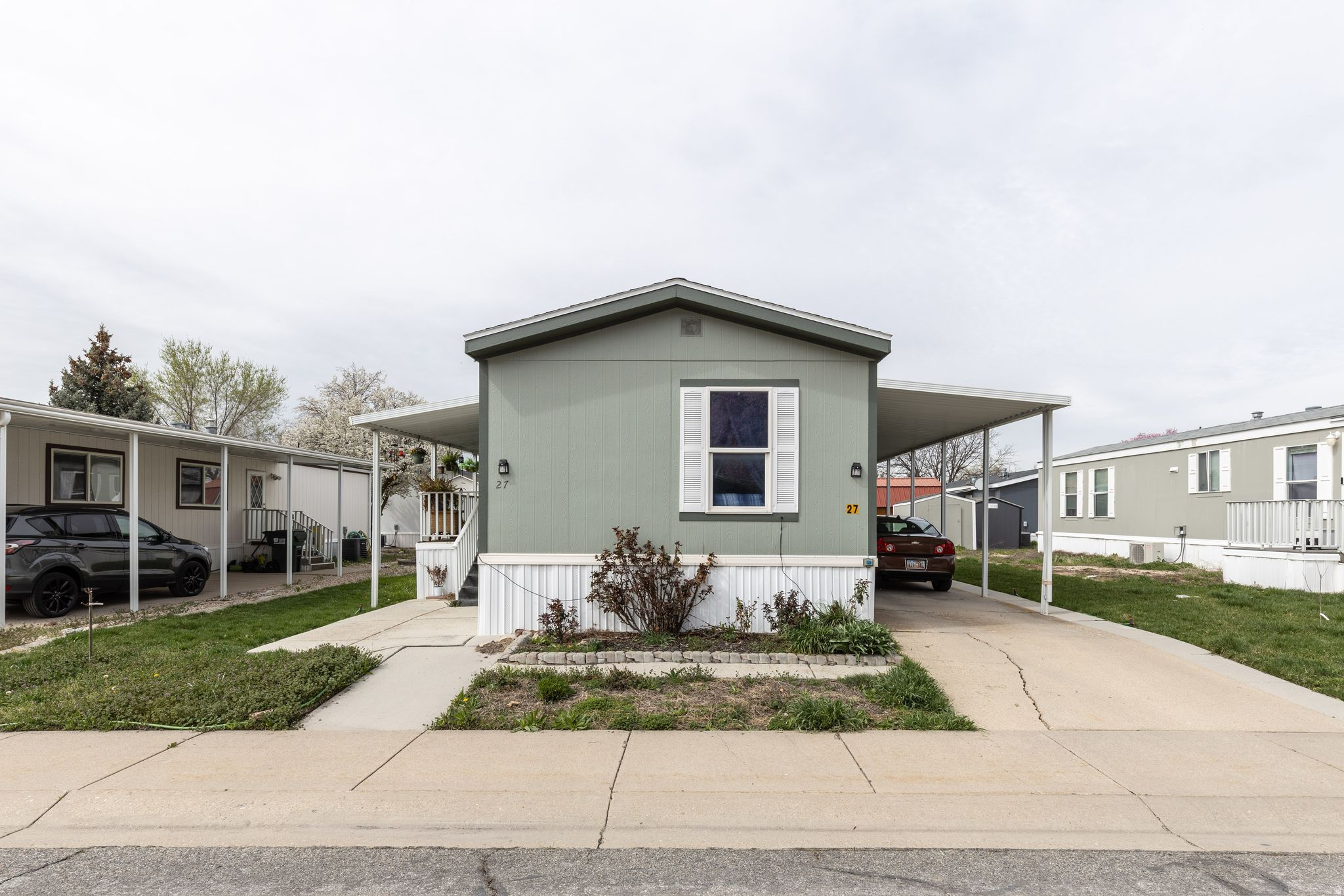 This has such a good feel to it when you walk into the front doors with open concept, livingroom, diningroom, kithen that is updated and so homie!!   You for sure need to check it out if you are looking for others in this well kept up park.  Has a pool, RV parking and a nice covered deck to sit out and enjoy your early morning time and evening down time and the mountain views. Primary has a private bath and on the oposite side of the home away from the primary there are 2 bedrooms and a separate bath for guest.  Just off the deck is a patio area in case you want to catch some sun rays.  Covered parking, and a easily manageable yard. Roof is in great shape. sewer and water paid