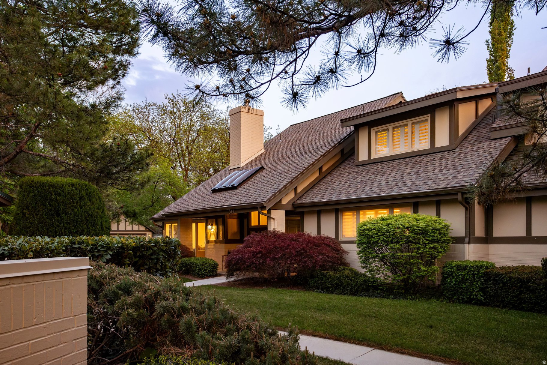 Nestled in one of East Millcreek's most sought-after gated communities, this charming property feels like coming home. Edgemount Estates is a thoughtfully curated retreat in which to settle, with  meandering walkways, mature trees, and professionally designed plantings. This unit seems to be especially designed to capitalize on the beauty of these surroundings. The large windows bring the outdoors inside, paired with soaring ceilings that gives a sense of spaciousness and light. The private outdoor patio is accessible from the great room, and the community pool is only steps away - perfect for personal use or family gatherings.The views can also be enjoyed from the large kitchen and adjacent sitting room, complete with a cozy gas fireplace. In addition to the gathering spaces, you will find that everything you need is on the main floor - a laundry room, a half bath, and a Primary Suite with a fireplace, loads of closet space and a soaking tub in the roomy bathroom. The upstairs has two additional guest bedrooms, both with ensuite bathrooms, and a useful den/craft-room in the loft area. Downstairs you will find two more bedrooms, a bathroom, and a large recreation room. The current owners have lovingly maintained and updated the home over the years, including a major kitchen remodel about 20 years ago and a more recent remodel of the upstairs & basement areas. They also added automated window coverings throughout. The roof has also been recently replaced, and the front porch & walkway have been redone to grant a no-step entry. Though Edgemount Estates is designed to feel secluded, this property is conveniently located with a freeway entrance only minutes away, offering quick access to skiing, hiking, downtown SLC, and the airport. Homes like this don't come around very often. With its ideal location, charming community, and classic cottage design, this is one you won't want to miss.