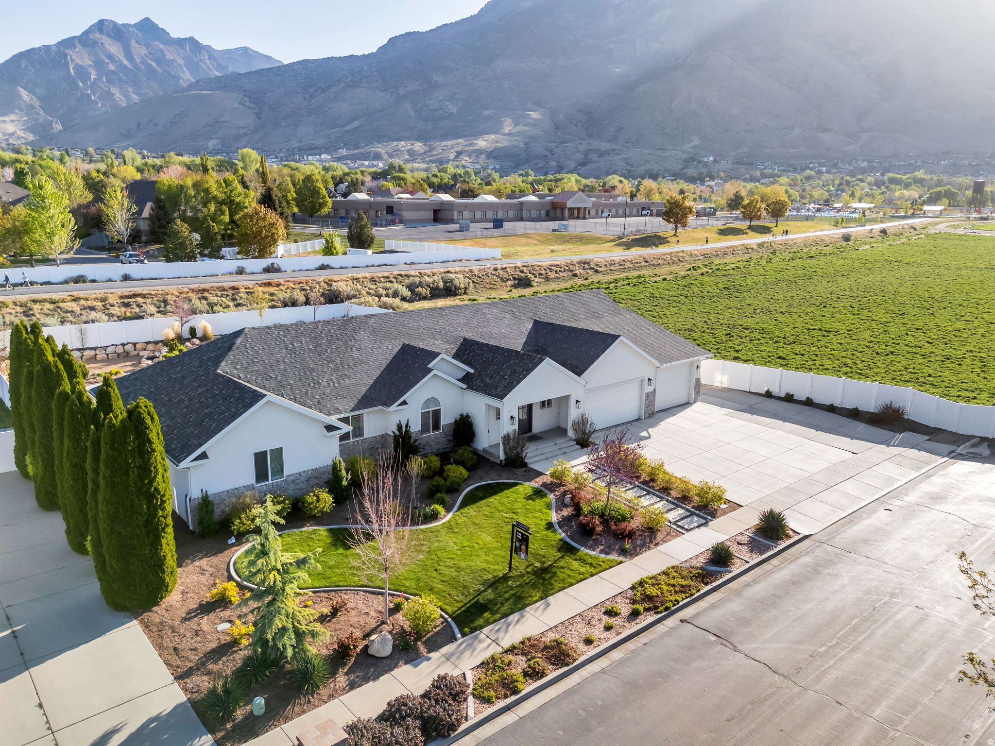 Tucked at the end of a quiet cul de sac in the highly sought after Val Vista Park neighborhood, this beautifully updated American Fork rambler delivers the kind of thoughtful design and lifestyle convenience that is hard to find at any price point. The heart of the home is an open concept main level where the kitchen flows effortlessly into the living area. The kitchen features sleek white cabinetry, a gas range, an oversized island, and a walk in pantry conveniently housing the fridge and microwave. The living area impresses with framed vaulted ceilings, a cozy fireplace flanked by built in cabinets and shelving, and an abundance of natural light. A dedicated flex room rounds out the main level, ideal as a home office or formal dining space. The primary suite is a true retreat, complete with dual sinks, a separate soaking tub and shower, a private toilet room, and an oversized custom walk in closet. Downstairs, the fully finished basement with a private garage entrance offers exceptional versatility, featuring a spacious secondary living area, dedicated theatre room, two bedrooms, a full bathroom, and ample storage. Outside, the fully fenced and landscaped backyard is designed for year round enjoyment with professional lighting, a fire pit, raised garden beds, in ground trampoline, and a gate that opens directly on the Murdock Canal Trail. A three car garage and dedicated RV parking offer storage, function, and flexibility all in one. Recent upgrades include luxury vinyl plank flooring (professionally installed March 2026), a ChargePoint EV charger (2024), and a Kinetico water softener (2022). Convenient access to parks, trails, great schools, and everyday shopping and dining. Measurements provided as a courtesy only, buyer to verify all info.