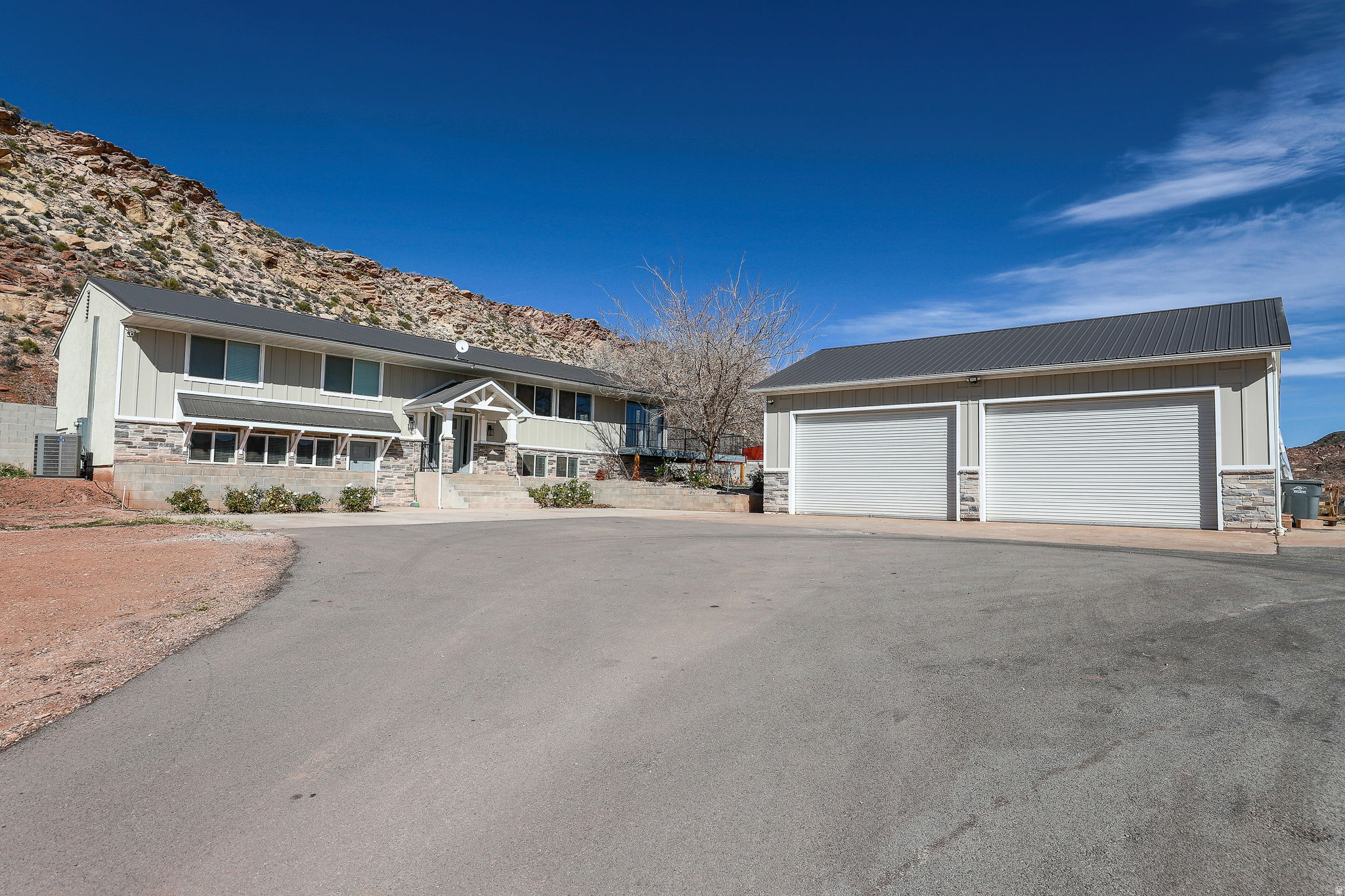 This rare 5.22-acre multi-use property in Leeds is priced to activate its full potential with a new $100,000 reduction. This is a vision-driven opportunity designed to connect buyers who can maximize land, infrastructure, and income potential--farm/ranch enthusiasts, investors, home-business operators, and luxury-estate seekers ready to capitalize.  Why this property stands out: expansive 5.22-acre parcel in Leeds with versatile A-5 zoning, two culinary water allotments and pressurized irrigation shares, major infrastructure in place, including a new tank septic system, option to secure a second permit for adding a second home/ADU or creating a multi-generational compound. 4,328 sq ft residence with 8 bedrooms and 6 bathrooms, offering abundant living and rental possibilities, large 4-car shop with 220V power, a lift, and a  bathroom; rear room rough finished and ready for renovation, 400-amp service positioned for auxiliary dwellings, shop equipment, and future expansion. Enjoy Hurricane Valley views toward Zion on your huge deck and in your newly landscaped private backyard.  Land, zoning & potential uses: A-5 zoning supports a wide range of uses: hobby farming, livestock, orchards/vineyards, gardens, and expansive outdoor living, ideal for combining agriculture with income streams (short-term/long-term rentals, guest accommodations, or studio/office space). Create a luxe live/work/investment compound or scalable development plan for future growth.  Infrastructure & improvements: new tank septic system, option for a second residence (requires a building permit to enable 2nd dwelling on the property, (would require a 2nd septic tank system install, allowed by SUPHD) and reliable utility readiness with 400-amp service to support multiple structures and equipment.  Residence details: 4,328 sq ft, 8 bedrooms, 6 bathrooms, 2 kitchens, 2 great rooms, designed to accommodate large families or multiple living/rental arrangements. ((MORE) More... This is a truly rare live/work/invest property where lifestyle, enterprise, and revenue can coexist. Rent out separate dwellings or spaces while developing the land for long-term value, an exceptional canvas for builders, agribusiness, equestrian ventures, or luxury estate projects. Take action -- bring your vision:schedule a private tour to explore the land, infrastructure, and the residence, and discuss how you can capitalize on this live/work/invest opportunity.
