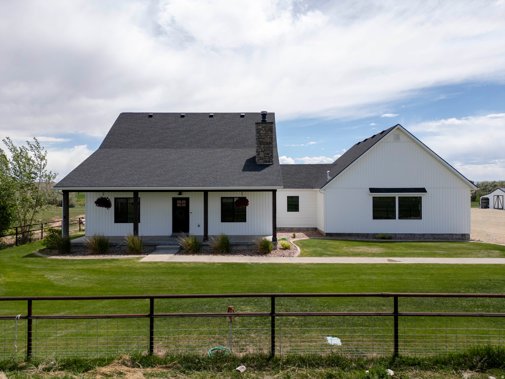 Welcome Home to this beautiful custom-built farmhouse home that sits on 9.6 acres! Peaceful country living with convenient access to town, you get the best of both worlds! This home is already set up for your animals, so get the horse trailer out and loaded, yee-haw! This 2-story home has so much charm and is impeccably maintained inside and out. Original homeowner shows pride in ownership! Front covered porch in the front & the back!  You will be "WOW" when you walk inside this home! Open concept with ginormous vaulted ceilings throughout. Real wood flooring, Wood burning stove with beautiful rock! The spacious kitchen has the country charm with granite, farmhouse sink, gas stove, oversized island, walk in pantry, built in garbage, slow close cabinets, the list goes on! Spacious Master suite is located on the main level w/dbl sinks, walk in closet & wait until you see the awesome Walkin shower w/dbl shower heads, yes, I said dbl. Let's head upstairs where the custom-built railing is so awesome! Spacious family room w/2 more bedrooms & full bath. Views inside & outside are breathtaking! Attached 950 sq. ft.  garage has 11' tall garage doors, fully finished, epoxy flooring, heated, insulated, hot & cold hookups & is ginormous!! Outside is just as awesome as the inside with a 30 X 30 pole barn w/ attached 15X30 enclosed cemented building that has power ran to it but not hooked up. Huge 16X16 Storage shed w/built in shelving w/ an attached covered woodshed on the side! 7 shares of Dry Gulch irrigation are included!  2 extra power boxes on the property if needed. Too much to list! Call now for your private showing of this beautiful home you won't be disappointed!
