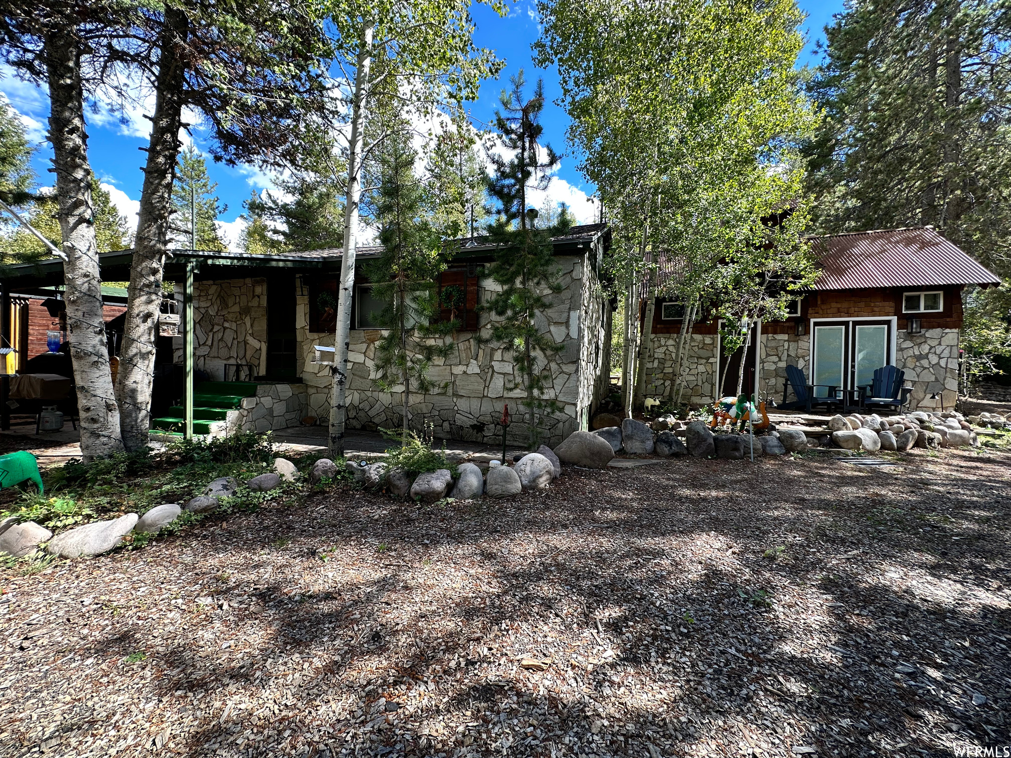 Escape to mountain living with this fully furnished Hidden Lakes cabin featuring a beautifully designed main cabin and detached bunkhouse, offering approximately 917 sq. ft of combined living space with 3 "rooms" and 2 bathrooms, while the detached 299 sq. ft garage provides excellent storage for outdoor gear, toys, or workshop space. Whether you're looking for the perfect weekend getaway, an investment opportunity, or a cozy year-round escape, this property was built for making memories.  Inside the main cabin, the open-concept design creates an inviting flow between the kitchen, dining, and living areas, perfect for gathering after long days on the lake or trails. Granite countertops, stainless steel appliances, and a spacious island bring both style and function to the kitchen, while sliding barn doors add warmth and mountain charm to the private bedroom spaces. The bathroom features a custom tiled walk-in shower that feels elevated yet comfortable.  The detached bunkhouse adds incredible flexibility with vaulted ceilings, a 3/4 bath, cozy loft space, and room for a king bed, bunks, or twin setup. Complete with a charming coffee nook and sink, it's the perfect setup for guests, kids, a creative studio, or your own private hideaway.  Step outside and enjoy everything Hidden Lakes has to offer, from private lake access and the nearby Weber River to endless trails for fishing, hiking, snowmobiling, ATV riding, and year-round adventure. Tucked away in the mountains yet conveniently located within a short drive to Park City, you can spend the day on the slopes or at dinner in town before returning home to peace, quiet, and star-filled skies.