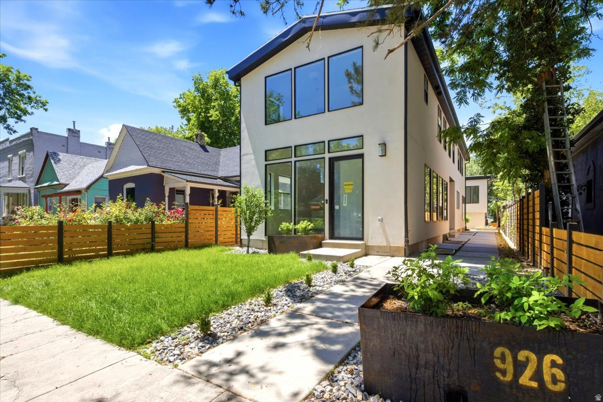 New construction in 9th & 9th is rare. New construction with over 4,000 square feet in the main home, a detached 2-car garage, and a separate 2-bedroom ADU is almost unheard of. Located at 926 S 800 E, this custom-built home offers the space and function of a modern city residence while sitting in one of Salt Lake City's most walkable and established neighborhoods. The main level was designed to feel open, bright, and connected from the moment you walk in. The living, dining, and kitchen areas flow from front to back, creating an ideal layout for gathering, entertaining, and everyday living. The kitchen is the centerpiece, featuring a full-length island, custom copper hood, custom cabinetry, 48" KitchenAid range, 72" refrigerator/freezer, and a butler's pantry with open shelving, wine cooler, ice maker, and bar sink. Folding patio doors open the home to the private yard and patio, creating a natural extension of the living space from the front entry through to the outdoor living areas. Upstairs, vaulted ceilings add volume throughout the entire level, with a second living room creating separation from the main floor. The primary suite feels like a true retreat, with its own laundry hookups, walk-in shower, freestanding tub, and a private, elevated feel. The additional upper bedrooms each have ensuite bathrooms, and individually zoned HVAC on each level adds comfort and efficiency throughout the home. The detached ADU above the garage is one of the property's most valuable features. Complete with two bedrooms, one bathroom, kitchen, and laundry, it lives independently from the main home and creates rare flexibility for rental income, guests, extended living, or a private office/studio. The full-height basement adds even more usable space with additional bedrooms, laundry, storage, and room for a dedicated workout area. But the true value is the location. 9th & 9th is one of Salt Lake's most loved neighborhood centers, with restaurants, coffee shops, boutiques, local businesses, and Liberty Park all nearby. In a neighborhood where lots are scarce and larger homes are hard to find, this property offers a nearly impossible combination of new construction, scale, walkability, finished landscaping, and ADU income potential. Square footage figures are provided as a courtesy estimate only. Buyer is advised to obtain an independent measurement. Owner/Agent.