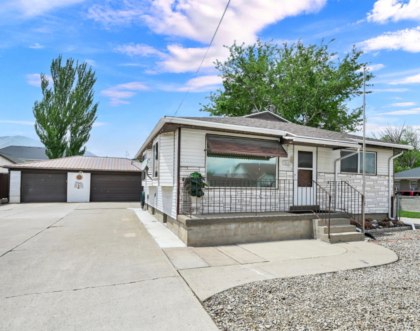 This home is looking for a buyer who will love it as much as the owners who custom built the perfect home for themselves in1960. They raised kids, who brought over grandkids who brought over great grand kids and for 66 years made wonderful memories for all 4 generations. This is the first time this home has ever been available to buy. The home sits on the eastern edge of the almost 1/2 acre lot and was built to make it easy to house your family, your pets, your vehicles, and your toys. Built as a 4 bed, 2 bath home but after all the kids grew up Mama traded in the 4th bedroom for a big roomy laundry room! The dad had all kinds of power tools and hand made many of the built-ins, the polished rock half wall, and the matching countertop on the downstairs bar. They used the smaller backyard for entertaining, and the larger backyard has had many uses. Originally horses walked the backyard and the out building was their barn! Fruit trees a plenty & vegetable gardens fed the family & a rousing game of horse shoes would often decide who did the dishes. Over the years it has morphed into a great frizbee and croquet yard, And the barn now houses lawn mowers and yard equipment. Besides a beautiful landscaped  lot, you also get a newer roof on the house, a lifetime metal roof on the 3 car garage, the single car garage has a door on each end to easily drive through to the backyard if needed. There are two concrete driveways on each side of the house & a circular rock driveway for easy come & go access from either side. RV parking for your largest toys, two covered patios, rock gardens, and even a decorative wishing well! Buyer to verify all, this home is being sold from a Trust and is being sold in as-is condition. As far as the trustee knows the systems and appliances are all in working order. See agent remarks regarding future street improvements.