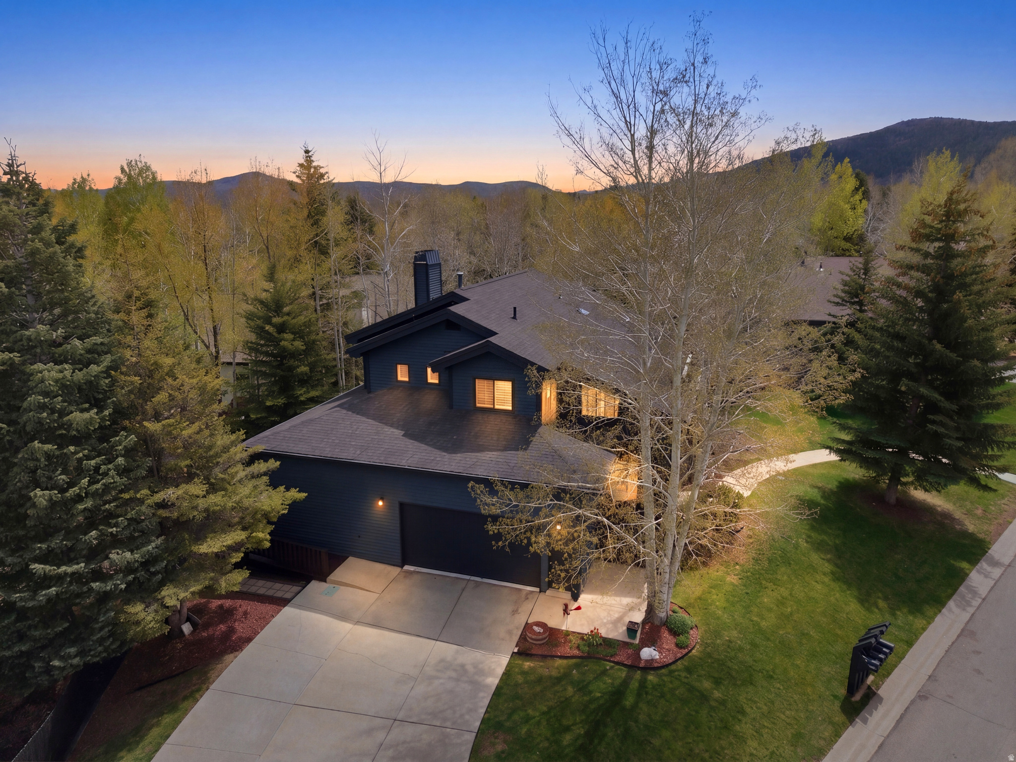 Remodeled in 2020, this stunning Silver Springs home pairs warm mountain style with everyday convenience and easy access to Parley's Park Elementary and the free bus line for quick access to skiing and trailheads. Step into the great room and you're greeted by a dramatic double-sided stone fireplace that anchors the main living and dining spaces. The dining area shines with ceiling height cabinets, while the light-filled kitchen features a large island designed for gathering, cooking, and conversation. The kitchen flows to an inviting outdoor living area ideal for entertaining or unwinding in the built-in hot tub while taking in ski-run views.  The main-level mother-in-law suite offers its own kitchen and living room, private bedroom, and bath. This flexible space works beautifully for guests, a home office, a play area, or private quarters for a nanny or au pair. Upstairs, the primary suite offers a walk-in closet and a luxurious, spa-like bathroom. Two additional bedrooms, a full bath, and a laundry area complete the upper level. On the lower level, you'll find a wonderful space with extra room, including a family room, bedroom, full bathroom, laundry, and multiple storage rooms.  Set in one of the area's most sought-after, family-friendly neighborhoods, the home is close to the community's little lake, with the larger lake and park just a short walk away, plus trails woven throughout the neighborhood. Having undergone an extensive professional remodel in 2020. Combining high-end finishes with a functional, multi-generational layout, new triple-pane windows this property is designed for both grand entertaining and quiet enjoyment.