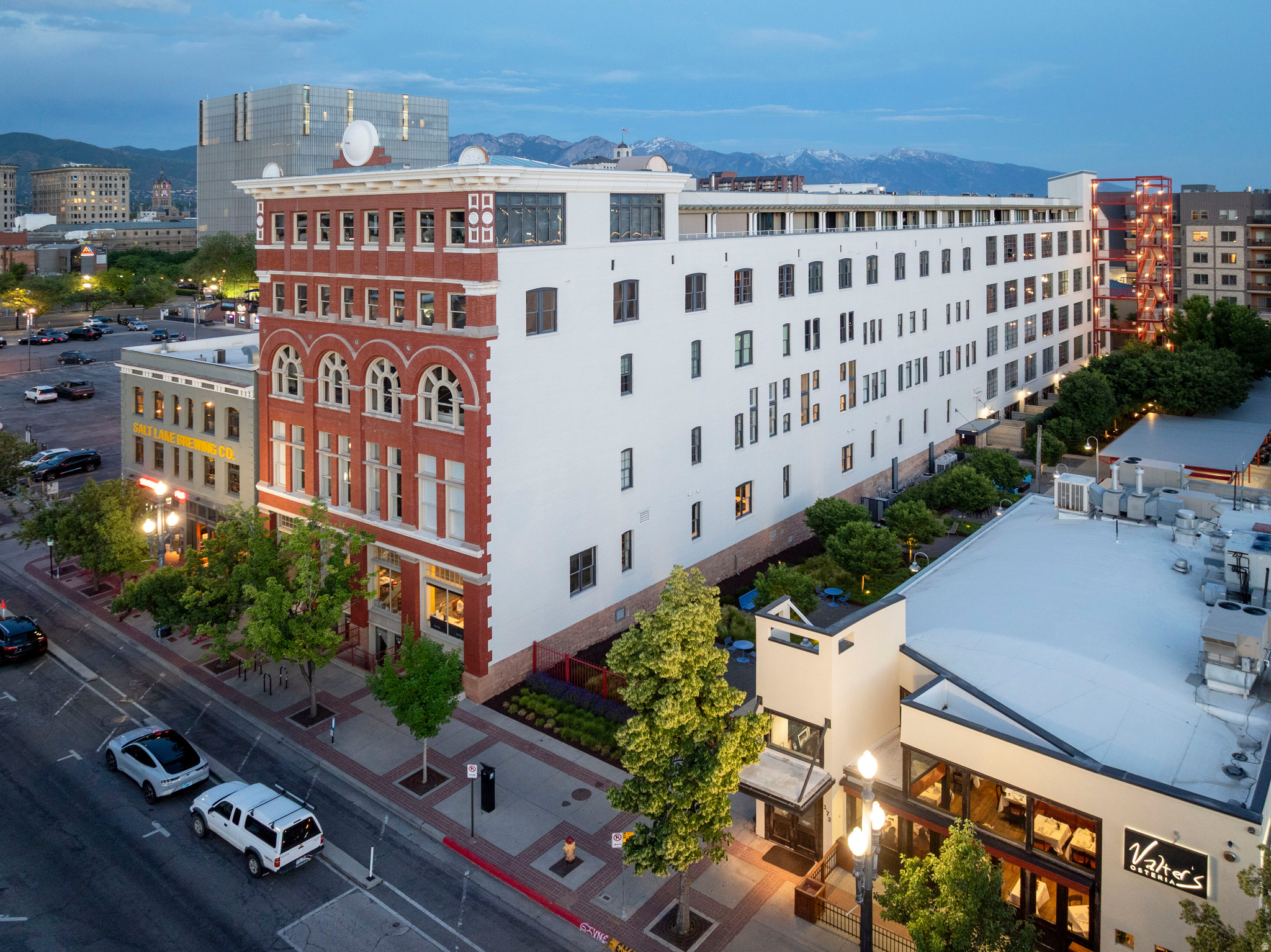 Authentic artists loft in the historic and ever so popular Broadway Lofts! This is a rare double height end space with giant real warehouse windows on three sides! The views are simply panoramic and incredible. Built in 1900 with brick and concrete which remain in textural intrigue! Floods of light enhance and change shades all day long. A true big city feel with a mezzanine loft space plus complete main floor living! The Italian galley kitchen looks upon the dramatic open layout. There are multiple living and dining options plus a glass walled main floor Primary suite. Two large, modern baths are each tasteful and unique. There is great storage . Studio and flex space plus the second bedroom are upstairs. This unit has long been noted as the premium loft space in the city. Fabulous gardens, patios and greenery enhance the wide open and large outdoor common area. A premium carport space comes with the package. The textures, views and dcor are simply magnificent. This building is an architectural treasure! Next door, at Edison House, you can join and enjoy world class dining, an amazing fitness center and swimming pool! Ultimate city center location!