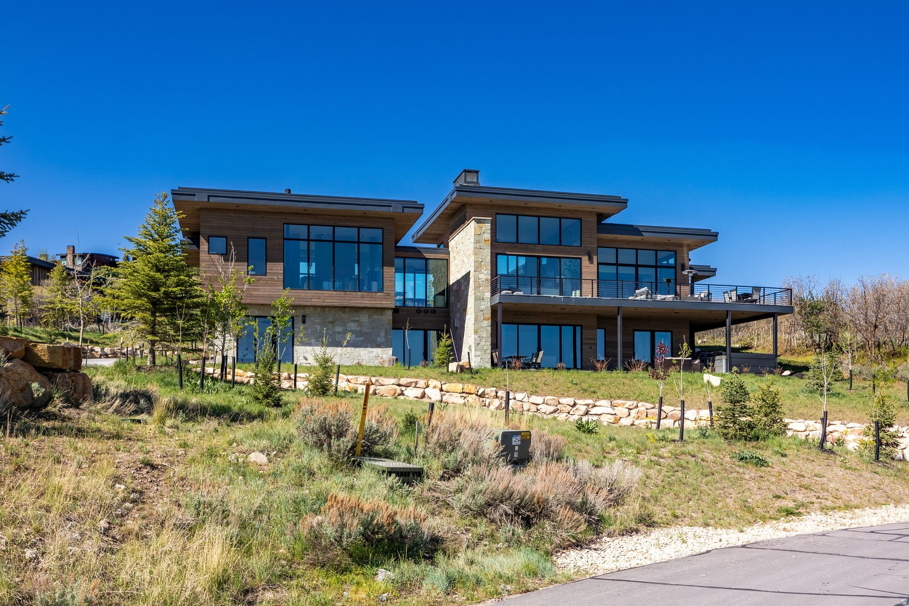 Welcome to 4027 Aspen Camp Loop-an elevated expression of mountain modern living in the heart of Promontory. Thoughtfully designed by Moxie Studios and built by Aecum Development, this residence blends refined architecture with effortless livability, offering a seamless balance of style, function, and multi-generational flexibility. Every detail has been considered to support both everyday comfort and elevated entertaining. Expansive walls of glass frame sweeping mountain views from nearly every room, filling the home with natural light and creating a constant connection to the surrounding landscape. The open-concept main level flows with ease into a chef's kitchen featuring Sub-Zero and Wolf appliances, a generous butler's pantry, and well-appointed spaces designed for gathering after a day on the mountain or the course. With six bedrooms and seven bathrooms-including a flexible office space-the floor plan offers both privacy and versatility. Each bedroom is en-suite, while the custom bunk room adds a thoughtful, functional touch with a three-sink vanity, ideal for hosting family and guests with ease. Comfort and convenience extend throughout with radiant in-floor heat, a heated driveway, and a three-car heated garage, ensuring year-round mountain living without compromise. A full golf membership to Promontory Club is available by separate written agreement.