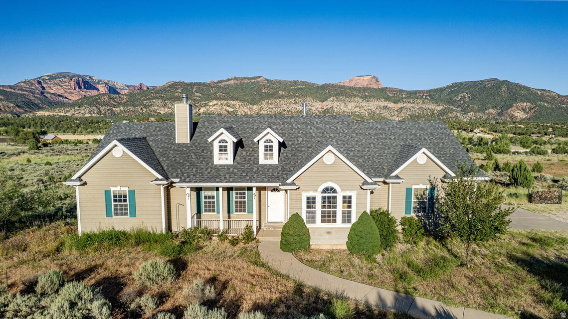 Nestled on 5 private acres in desirable New Harmony Ranches, this spacious home offers breathtaking, unobstructed views of Kolob Canyon and Pine Valley Mountain. A natural tree screen provides privacy from the road, while the raised concrete deck captures stunning Southern Utah scenery. Inside, the bright, flowing floor plan features a cozy den with a wood-burning stove and view windows, plus a spacious living room with built-ins, a raised fireplace hearth, and panoramic views. The split-bedroom layout offers privacy, with two guest bedrooms opposite the primary suite, including one with direct deck access. The unfinished walkout basement provides exceptional expansion potential with space for additional bedrooms, a gym, workshop, or recreation area. Bring your horses or livestock and enjoy peaceful rural living just minutes from Kolob Canyon, Kanarra Falls, I-15 access, and New Harmony amenities. A rare combination of privacy, views, acreage, and future potential.