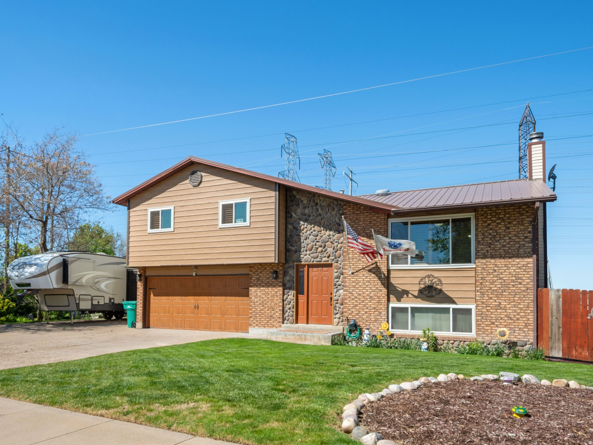 This stunning, custom-built home is meticulously maintained and boasts a range of amenities perfect for family gatherings and entertainment. The beautifully landscaped 0.71-acre lot offers a park-like setting with mature trees, a spacious garden, a built-in fire pit, and no neighbors behind-just charming horses in an open country field for added privacy. The walkout daylight basement opens onto a generous covered patio equipped with a gas line, ideal for barbecuing or creating an impressive outdoor kitchen. Enjoy a relaxing hot tub area year-round, which complements the inviting warmth of the wood-burning stove set in stone and the rustic wet bar. Upstairs, the highlight is a grand, lodge-style vaulted family room featuring stonework, tongue-and-groove pine, stately beams, a remote-controlled ceiling fan, and an electric log fireplace big enough to accommodate everyone. Step out onto the deck to take breathtaking views of the yard, beautiful sunsets, or a morning coffee. Inside, the home offers a spacious master bedroom, elegant plantation shutters, charming built-in shelving over the windows, a cultured marble tub surround, solid surface countertops, stainless steel appliances, and a high-efficiency furnace. Exterior features include river rock and brick accents, and a metal roof. The oversized garage fits a pickup truck and provides built-in shelving, painted walls, and a plumbed sink, while RV parking spans a generous 24 feet in width. Homes in this condition and with such large parcels are rarely available in Davis County. The property permits one large animal, two medium animals, and up to eight small animals. THE ENTERTAINMENT CENTER AND SIOME OF THE FURNITURE WILL STAY WITH THE HOUSE.