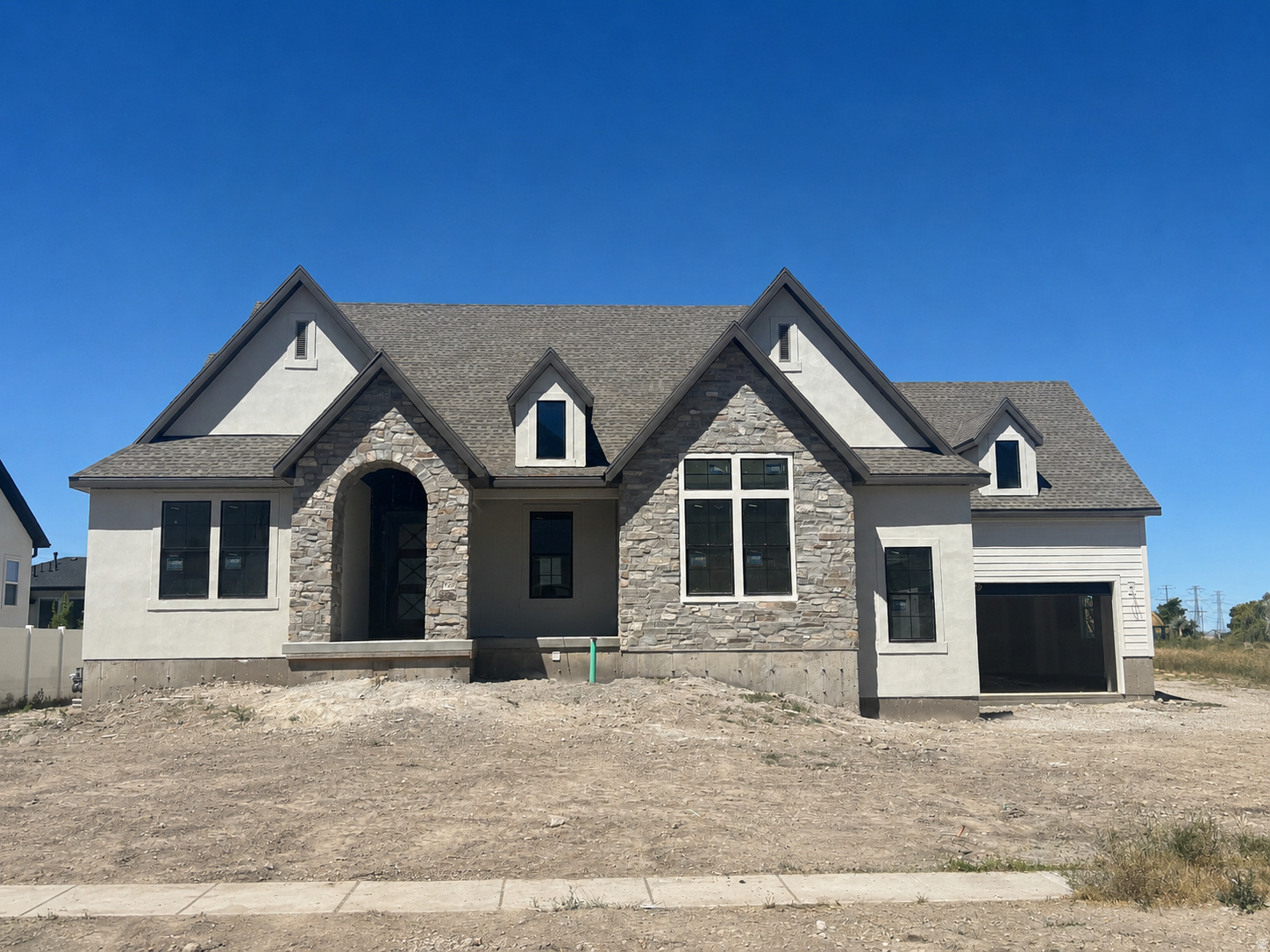 LOT#517. This Treble XL with a European Romantic elevation is one of Symphony Homes best-selling plans. Tons of upgrades throughout! This home is currently under construction and due to be completed in October 2026. Features a true 4-car garage (two 2-car doors) that will be finished to paint. 29x12 covered deck. Enormous Primary Suite has an oversized walk-in shower with built-in bench, freestanding tub, separate vanities, and will have a custom finished wardrobe room with a laundry hookup for convenience. Family room will feature knotty alder wood beam 11' ceiling and a custom fireplace. Kitchen will be equipped with upgraded appliances, including 48" dual fuel gas range, built-in side by side fridge & freezer, and an oversized walk-in butler's pantry with countertops and outlets. Huge dining nook. Finished basement will have 3 bedrooms, 2 full bathrooms, a laundry room and more for entertaining...You'll love the open theater with bar seating, beautiful wet bar, and true walkout basement to backyard patio. Lots of storage space throughout. Quality LVP flooring, extra high ceilings. Large covered patio. Amazing craftsmanship and interior design throughout. List price includes 90k in full yard landscaping.
