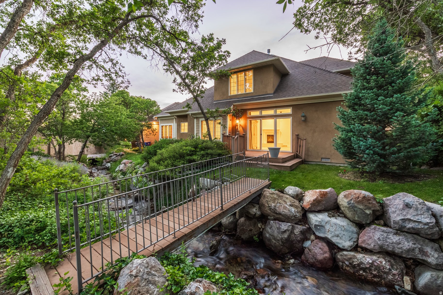 Tucked away behind a private electric gate on the Upper East Bench of Cottonwood Heights, this exceptional two-story home, built by Ron Ferrin, offers 3,286 square feet, four bedrooms, 3.5 baths, and a large two car garage on a beautifully landscaped .39 acre lot.  Mature trees, mountain views and a soothing seasonal stream from Deaf Smith Canyon create a peaceful and private setting.  The home features main floor living with the primary suite, dedicated office with built-ins, two fireplaces, wood plantation shutters and a large, open kitchen with granite counters, gas range and adjoining dining spaces. Upstairs, spacious bedrooms with walk-in closets provide abundant storage and comfort. Ideally located just minutes from Big and Little Cottonwood Canyons with world-class skiing, hiking , and outdoor adventures. A rare opportunity to purchase separately or together with adjoining 3450 Hidden Oak Drive, a 5,300 square foot luxury residence to create a extraordinary multigenerational estate or family retreat.