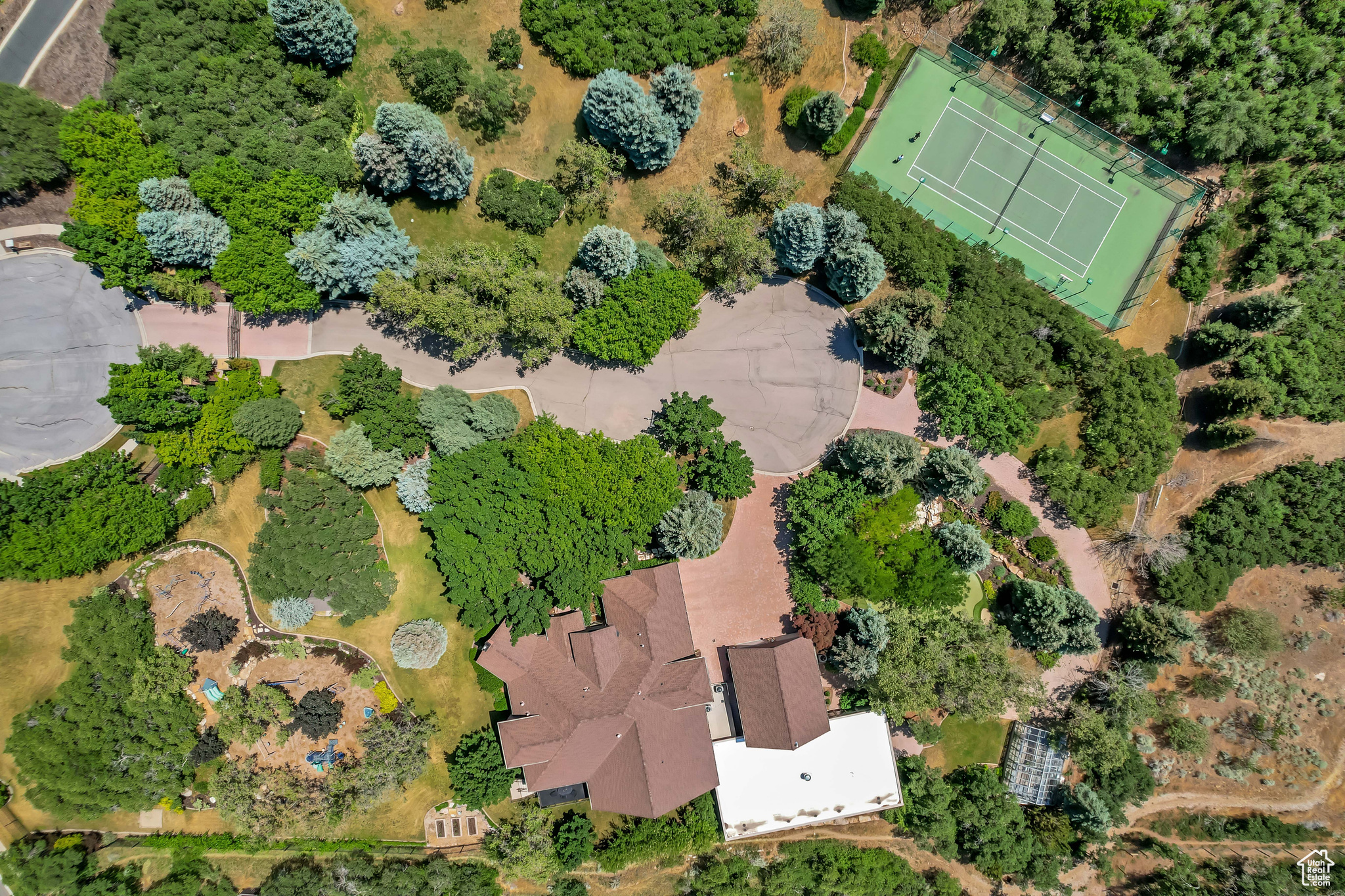 Nestled in the prestigious Holly View Acres, this 7.58-acre estate offers an extraordinary combination of luxury, privacy, and investment potential. Situated on a quiet cul-de-sac, the property is fully gated and fenced, ensuring peace of mind while embracing breathtaking 360-degree mountain views. With four total parcels, this estate presents a rare opportunity to develop, expand, or create a private retreat that backs directly up to US Forest Service Land, preserving privacy and views. The formal living room makes a dramatic first impression, featuring a vaulted ceiling, exposed wood beams, and a luxurious fireplace that serves as the focal point of the space. Expansive windows allow for abundant natural light, highlighting the warmth and elegance of the room. Just beyond, the kitchen is designed for both functionality and entertaining, featuring double wall ovens, a built-in countertop gas range, and a semi-formal dining space. A formal dining room sits adjacent, offering the perfect setting for hosting and entertaining. At the heart of the home, the Great Room boasts a soaring vaulted ceiling, and seamlessly connects to the balcony deck, creating an effortless indoor-outdoor living experience. Enjoy single level living with the Primary Suite on the Main Level, providing a luxurious retreat complete with an oversized shower, jetted soaker tub, and a connecting den with built-in hardwood shelving and workspace for work or relaxation. With 7 bedrooms and 6.5 bathrooms, this home offers abundant space for family and guests alike. Laundry rooms on every level add convenience to daily living, ensuring ease and efficiency throughout the home. The walkout basement is designed for versatility, featuring a full kitchen, designated dining area, and family room with its own separate entrance, making it an ideal mother-in-law apartment, guest suite, or private retreat. The basement is also host to a theater room with stadium seating, making family nights & entertainment at home a breeze. A dedicated wellness and recreation prep area within the basement includes a separate bathroom, shower, Finlandia Sauna, and a Suitmate Swimsuit Water Extractor, ensuring a spa-like retreat after a swim or workout. The indoor heated pool and spa is housed separately from the main residence yet remains easily accessible through the basement entrance. Designed for year-round enjoyment, this space features sliding glass doors around the structure, allowing for an open-air experience when the weather is nice. The surrounding area provides ample room for games, activities, and hosting, making it an entertainer's dream. Stepping outside, the backyard is a paradise for recreation and relaxation, featuring play gyms and equipment for kids, a putting green, a tennis court, and a large greenhouse for homesteading. Whether enjoying outdoor activities or simply taking in the breathtaking scenery, this estate offers an unmatched setting for enjoying the great outdoors. With a stunning paver driveway and oversized 3-car garage with plenty of room for vehicles, toys, and storage, this Estate truly is the perfect blend of practicality and luxury. With its prime location, expansive acreage, and endless amenities, this estate is a rare find in Alpine. Don't miss the opportunity to experience this one-of-a-kind property-schedule a private tour today! Buyer/Buyer's Agent to verify all.