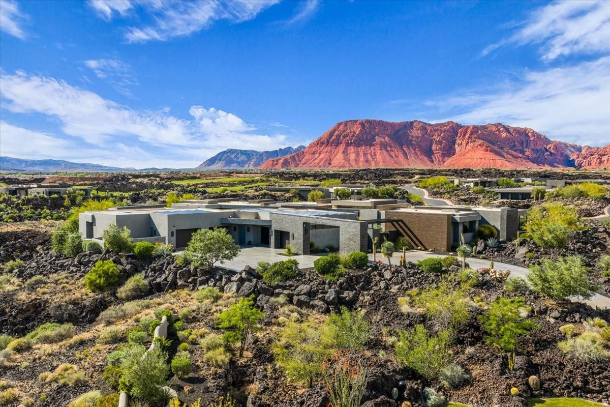 Unprecedented in quality and bold in vision, Bridges is a market-defining St. George estate that rises to a category of its own. Set across 2 natural ravines on 2.47 private acres within Entrada at Snow Canyon -- St. George's most exclusive guard-gated enclave -- this 16,302-SF, 2-level architectural retreat encompasses 5 bedrooms and 9 baths, with walls of windows and light-filled hallways capturing unobstructed views of Snow Canyon, Red Mountain, and every day's sunrise and sunset.  The estate's unrivaled location is immediately adjacent to the iconic Black Desert Resort, home to one of Utah's top-rated golf courses and host of the PGA Tour's Black Desert Championship. Snow Canyon State Park, The Tuacahn Center for the Arts, and Red Mountain trails are all minutes away, while Downtown St. George's restaurants and shops are just 15 minutes from home.  Inside, the chef's kitchen is engineered for large-scale entertaining, complete with 3 Sub-Zero refrigerators/freezers, 2 Sub-Zero wine coolers, 5 Wolf ovens, a Wolf range and grill, a Miele coffee system, dual dishwashers, and a spacious walk-in pantry. The private primary suite includes dual primary closets, dual primary water closets, and fireplace, while expansive ensuite bedrooms make the home ideal for multi-generational living. An extra-large Savaria elevator connects both levels.  Entertainment and wellness amenities include a 3-tiered private theater with a 143-inch screen, 68 in-wall speakers and 13 subwoofers throughout the home, caf and game room, and commercial-grade gym with steam room. Outside, a resort-style pool, covered cabana, built-in BBQ, and putting green overlook dramatic lava rock terrain and native desert plantings.  This estate's infrastructure is equally extraordinary, with closed-cell foam insulation, full Control4 automation, Lutron shades, 108 solar panels, a 48kW whole-home generator, heated floors, and 24/7 security. Bridges is, simply put, St. George's new benchmark for refined, future-proof design.