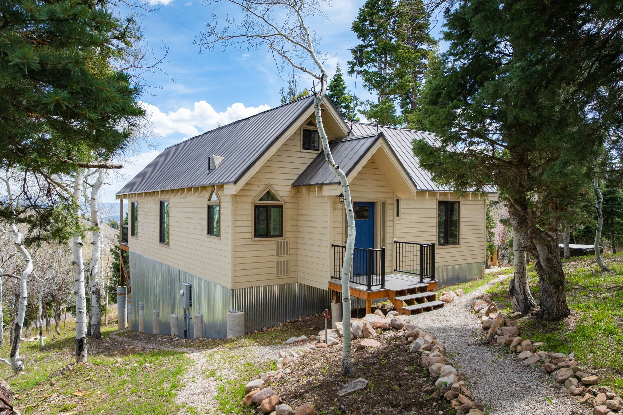 Tucked at the end of a quiet road in Stagecoach Estates, this mountain retreat offers a rare combination of privacy, natural beauty, and convenience. Set on ten acres of aspens, pines, and oak trees, the property captures sweeping views of the Uinta Mountains while offering a peaceful setting just 15 minutes from Kimball Junction. A gentle seasonal stream winds through the land, while moose, elk, deer, owls, and rabbits regularly pass through, creating a true connection to the surrounding landscape. Designed for comfort and simplicity, the cabin welcomes you with an open living space centered around a classic wood-burning stove. Large windows frame the mountain views and fill the home with natural light, creating a warm and inviting atmosphere throughout every season. The main bedroom provides a restful retreat, while the bright loft offers flexibility as a second bedroom, office, or creative space. Thoughtful updates throughout the home blend rustic character with modern convenience. Improvements within the past five years include new windows and doors, a remodeled bathroom, updated stainless steel appliances, washer and dryer, freezer, instant water heater, and water softener. Electric heat complements the wood-burning stove for year-round comfort. A detached workspace with Starlink internet creates an ideal setup for remote work or creative projects surrounded by nature. Below the main living area, a spacious shop or studio offers excellent room for storage, outdoor gear, snowmobiles, dirt bikes, or hobbies. Offered fully furnished with timeless mountain decor and original artwork, this retreat is ready to enjoy from day one. Spend mornings on the deck overlooking the mountains, afternoons exploring the surrounding outdoors, and evenings relaxing in the hot tub beneath a sky full of stars.